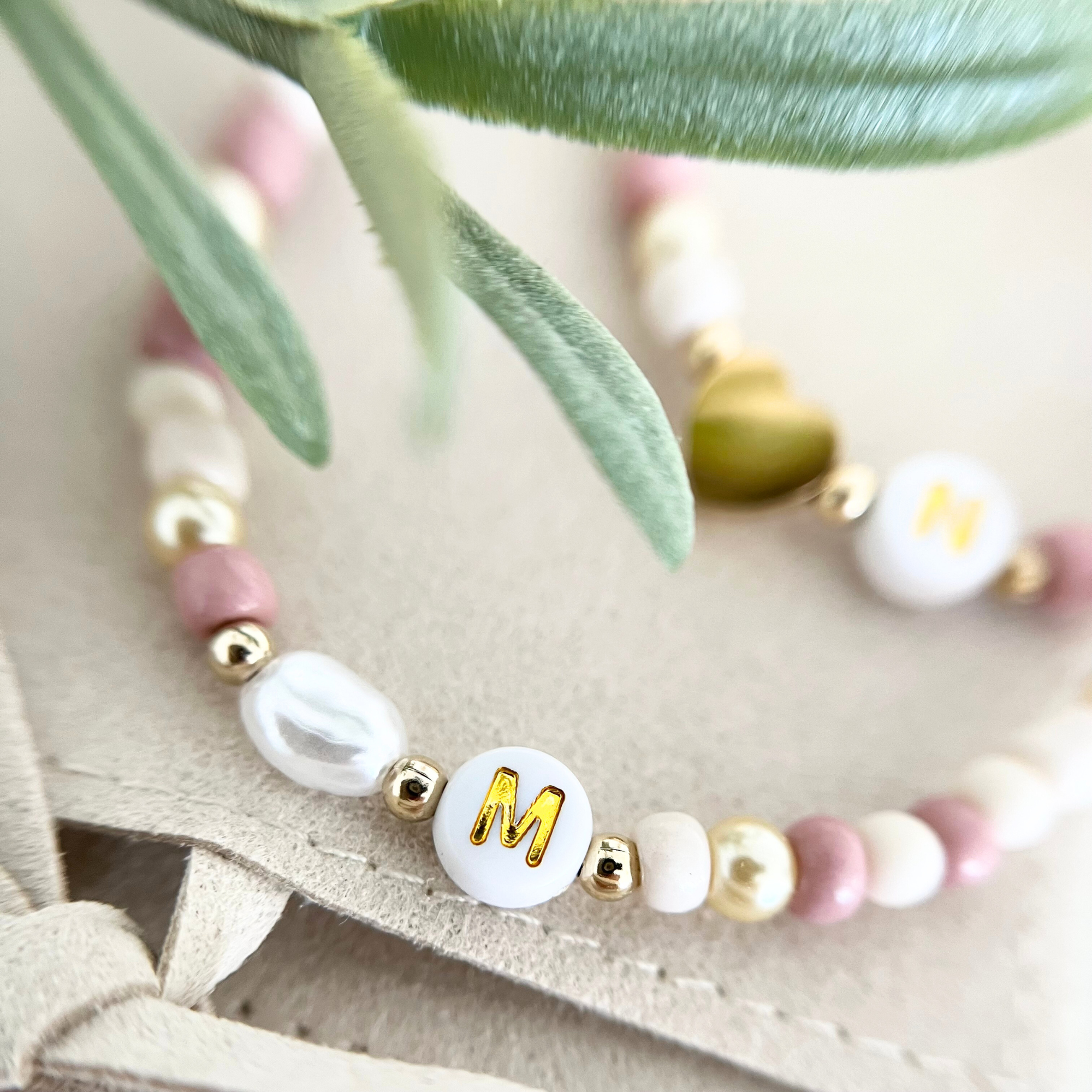 Nahaufnahme vom Armband mit Anhänger „M“ – personalisiertes DIY Armband mit Buchstaben für individuelle Geschenke und kreative Junggesellinnenabschiede.