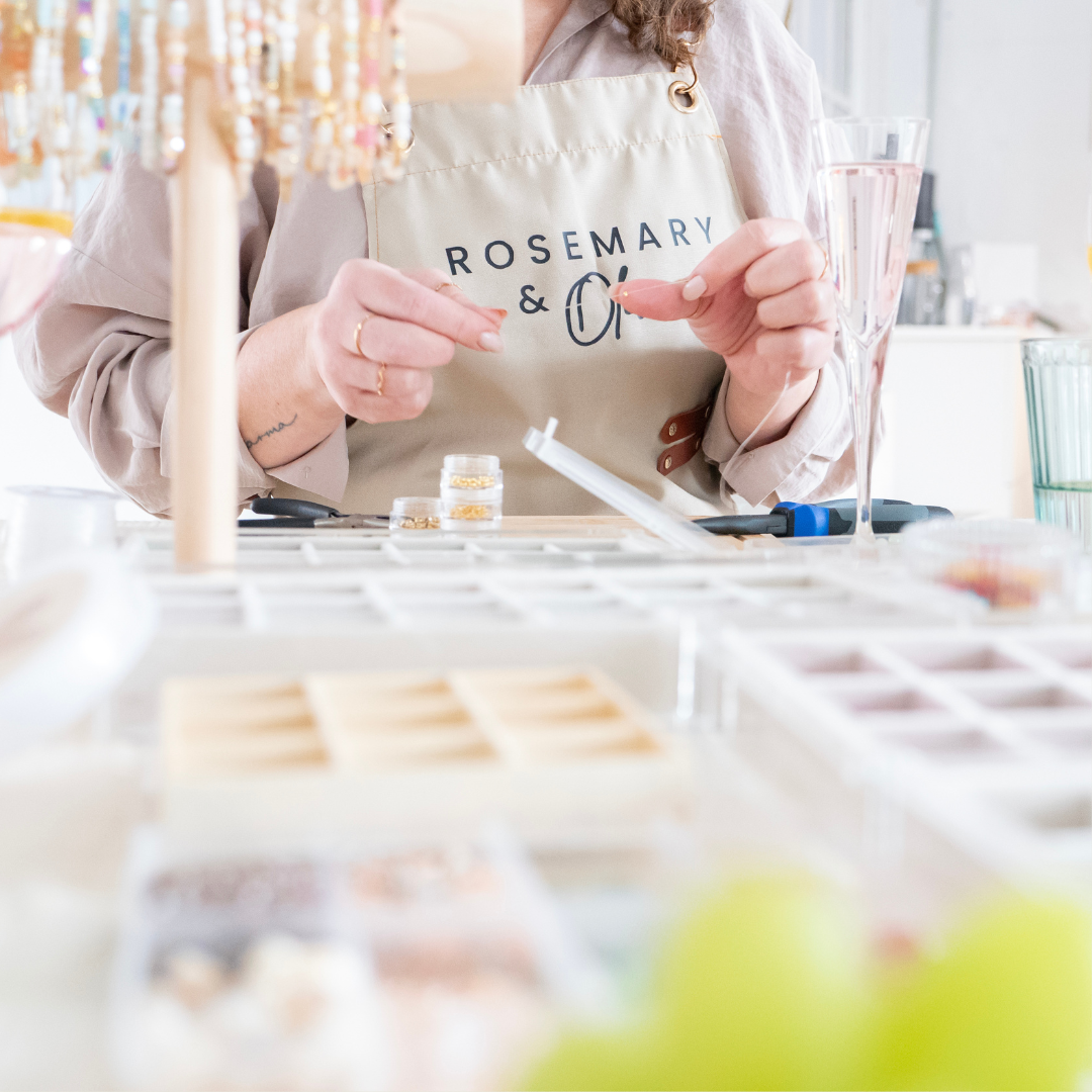 Schmuck Workshop in Wuppertal: Teilnehmerin fertigt Armband mit goldenen Perlen und Edelstahlteilen im DIY Kurs für handgemachten Perlenschmuck