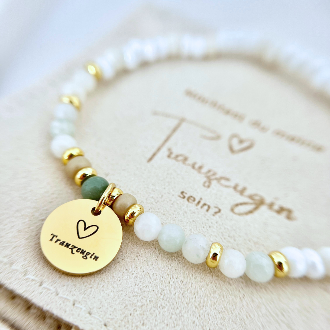 Zartes Perlenarmband mit goldenem „Trauzeugin“-Anhänger auf Geschenkverpackung – perfektes Geschenk, um die wichtigste Frage an deine beste Freundin zu stellen.