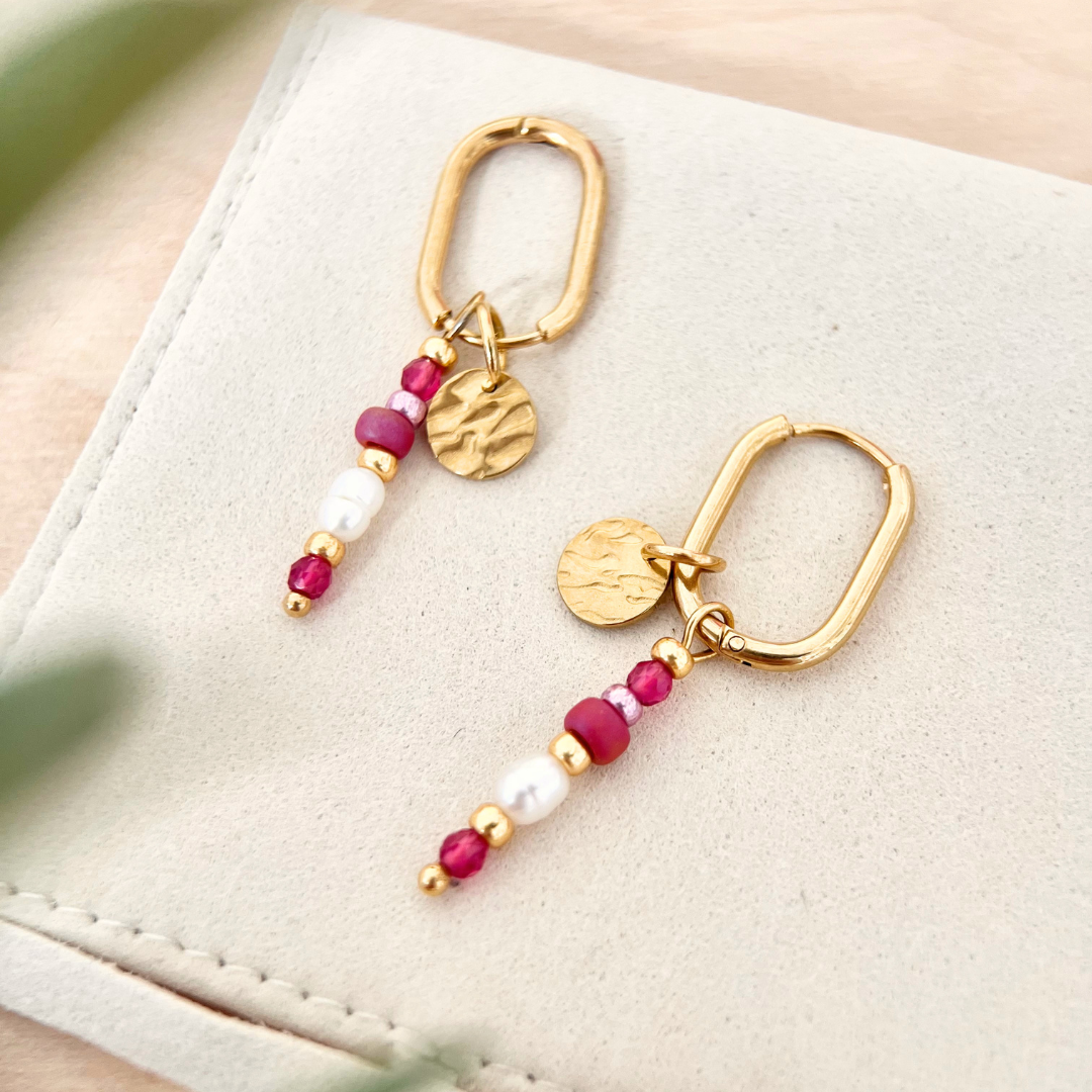 Goldene Creolen mit Perlenanhängern in Rosa, Pink und Weiß auf beigem Schmuckbeutel, minimalistisches Produktfoto, Schmuck für Frauen