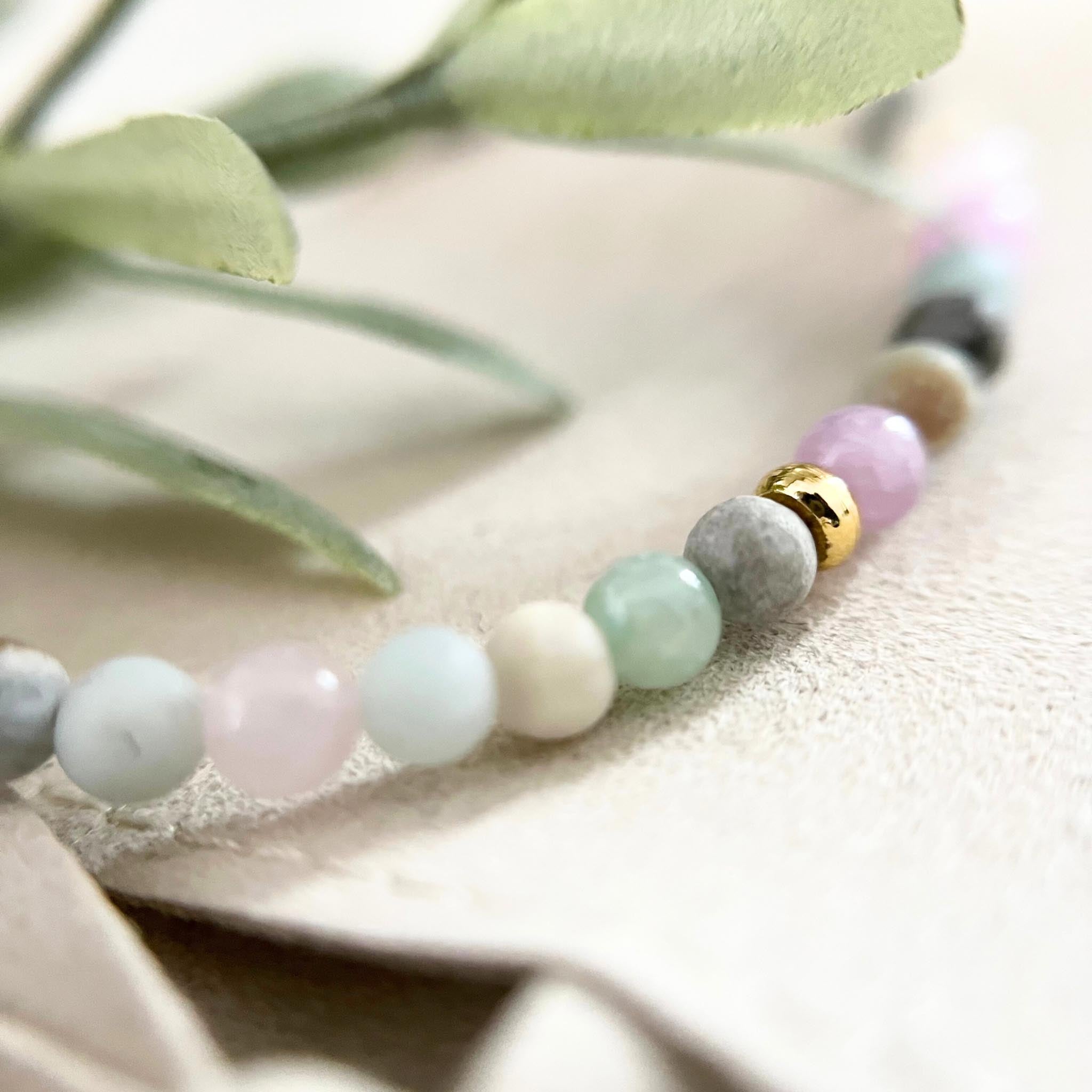 Seitliche Ansicht des Armbands PORTOFINO, das Edelsteinperlen, Natursteinperlen und Rosenquarz zeigt, mit edlen vergoldeten Akzenten