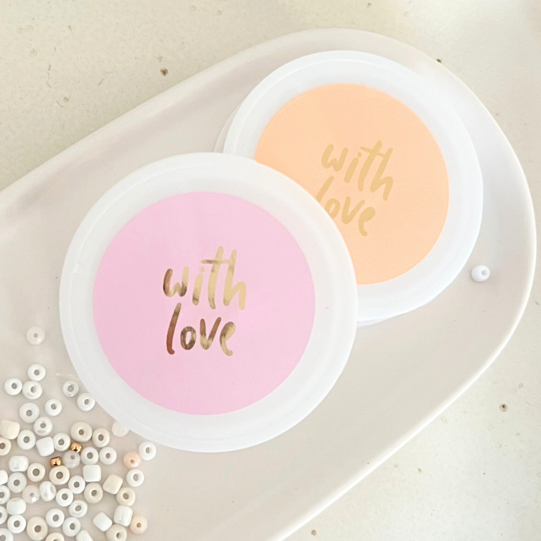 Bild von Teller mit Aufschrift "With Love" und ein paar Perlen daneben – kreative Details aus dem DIY Schmuck Workshop Wuppertal