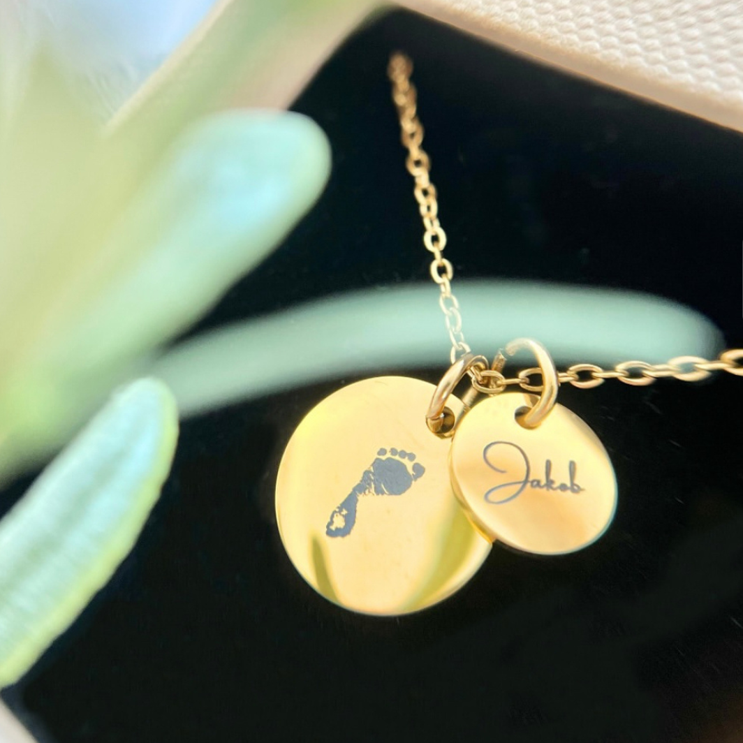 Personalisierte Gravur Kette aus Edelstahl in Gold mit Babyfuß- und Namensgravur „Jakob“. Erinnerungsschmuck und Geschenk zur Geburt.