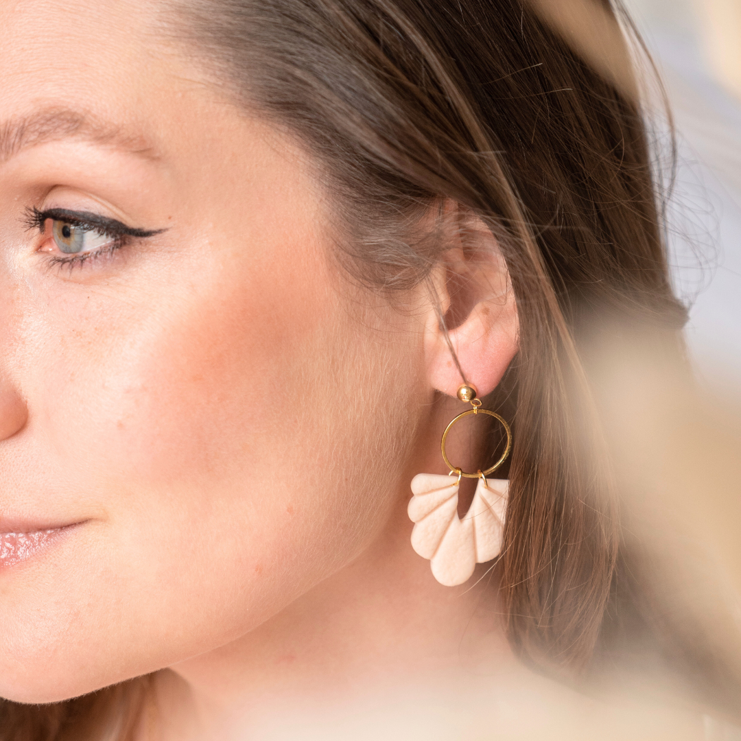 Getragener DIY Ohrring aus beigem Polymer Clay in Muschelform, kombiniert mit einem goldfarbenen Edelstahlstecker und großem Metallring – handgemachter Statement-Ohrring aus dem Schmuck Workshop in Wuppertal