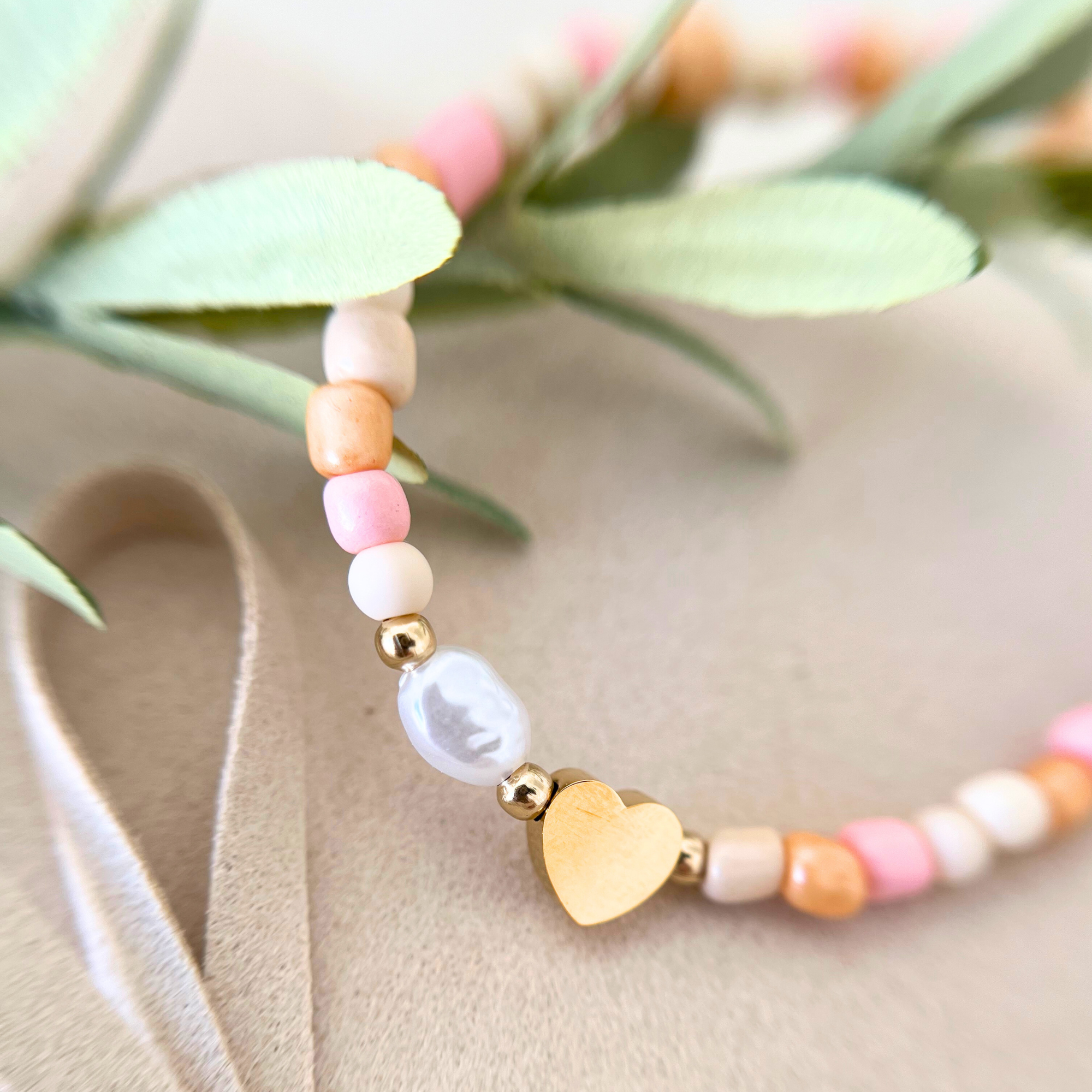 Nahaufnahme von Perlenarmband mit goldfarbenem Herzanhänger und weißer Perle, DIY Armband Set ALBA