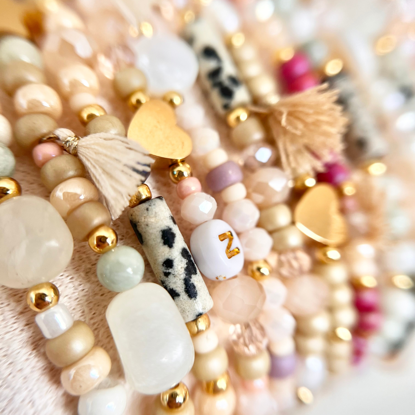 Detailaufnahme aus dem Premium JGA DIY Armband Bastelset mit Natursteinperlen, Glasperlen, Buchstabenperlen, goldfarbenen Edelstahlperlen und Boho Quasten – hochwertige Materialien für DIY Freundschaftsarmbänder beim Junggesellinnenabschied.