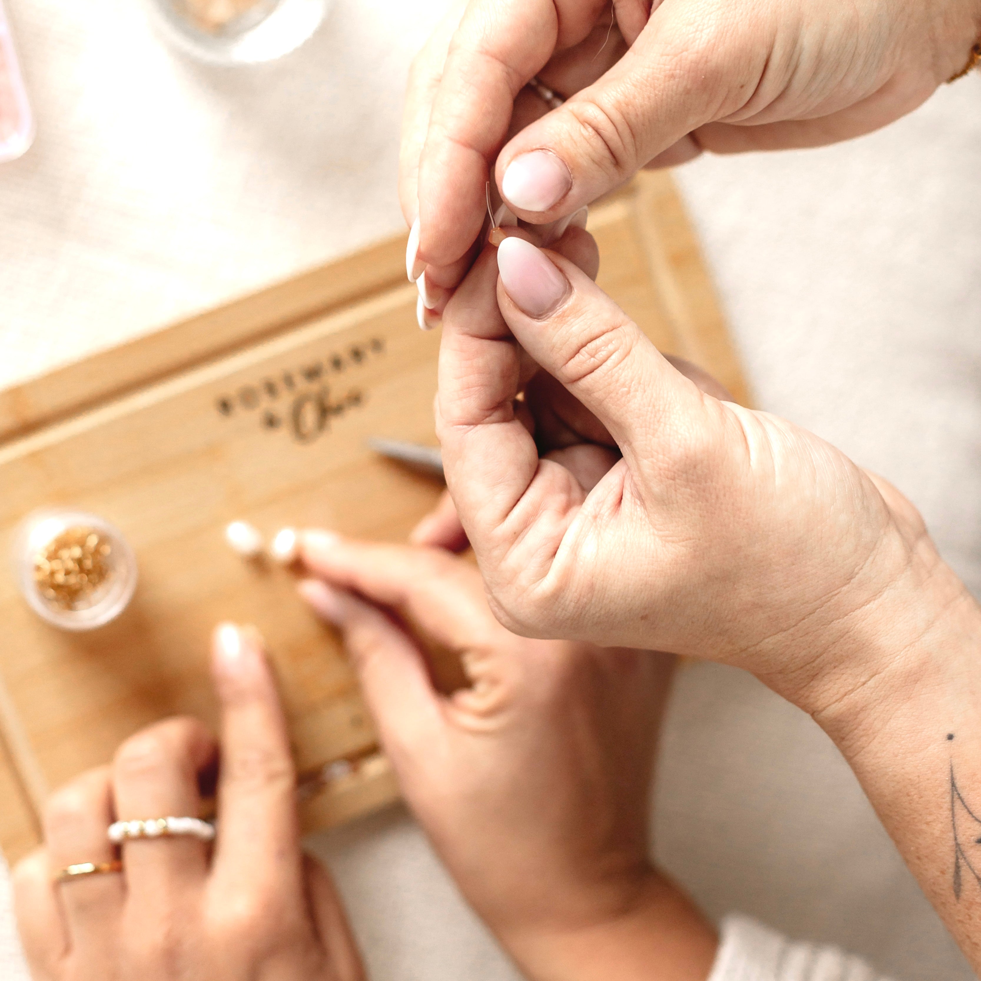 Zwei Hände halten ein Armband aus dem DIY Kit – handgemachte Armbänder für kreative Stunden.