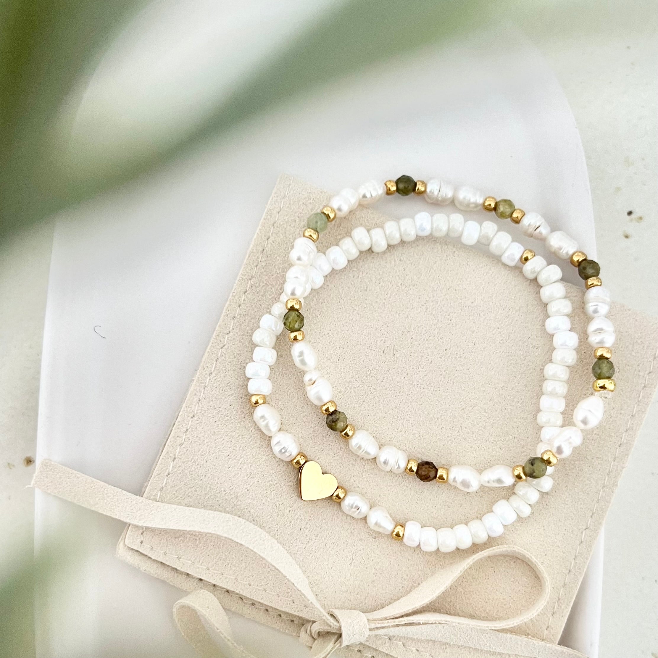 Freundschaftsarmband-Set auf Schmuckbeutel mit Schleife – Süßwasserperlen, grüne Natursteine und goldene Herzperle harmonisch arrangiert.