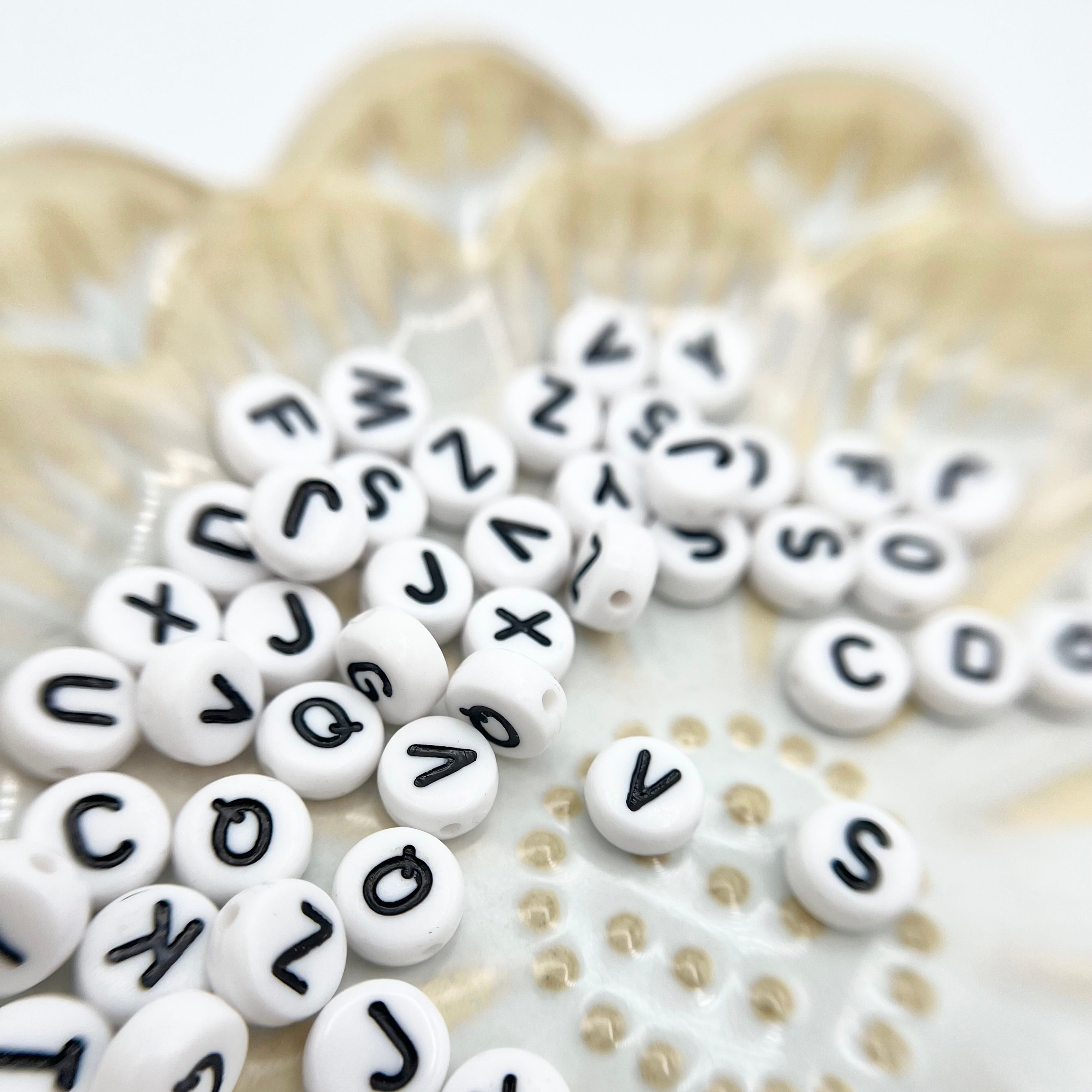 Verschiedene Anhänger mit Buchstaben aus dem DIY Kit – personalisierte Armbänder für besondere Erinnerungen.