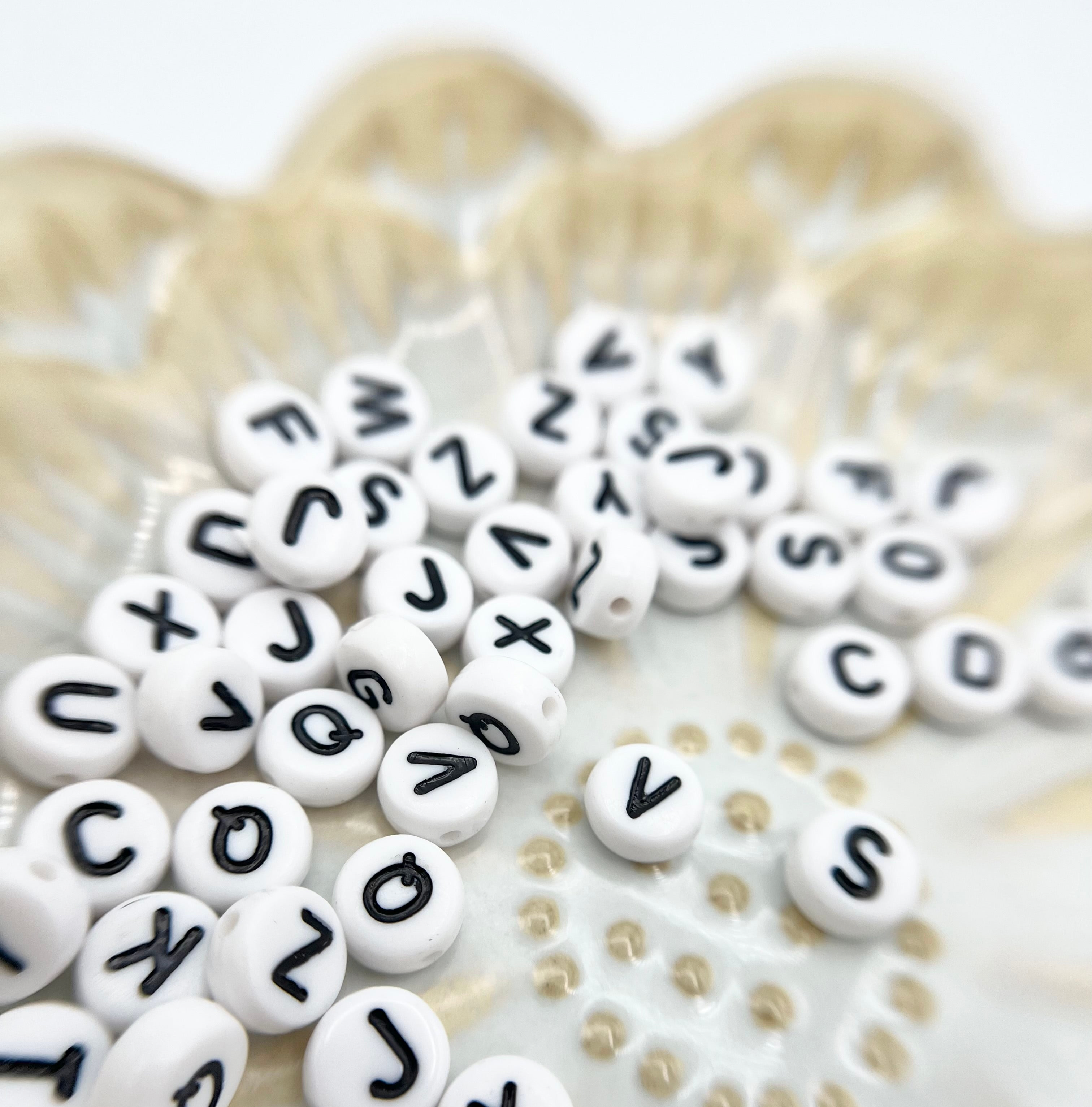 Verschiedene Anhänger mit Buchstaben aus dem DIY Kit – personalisierte Armbänder für besondere Erinnerungen.