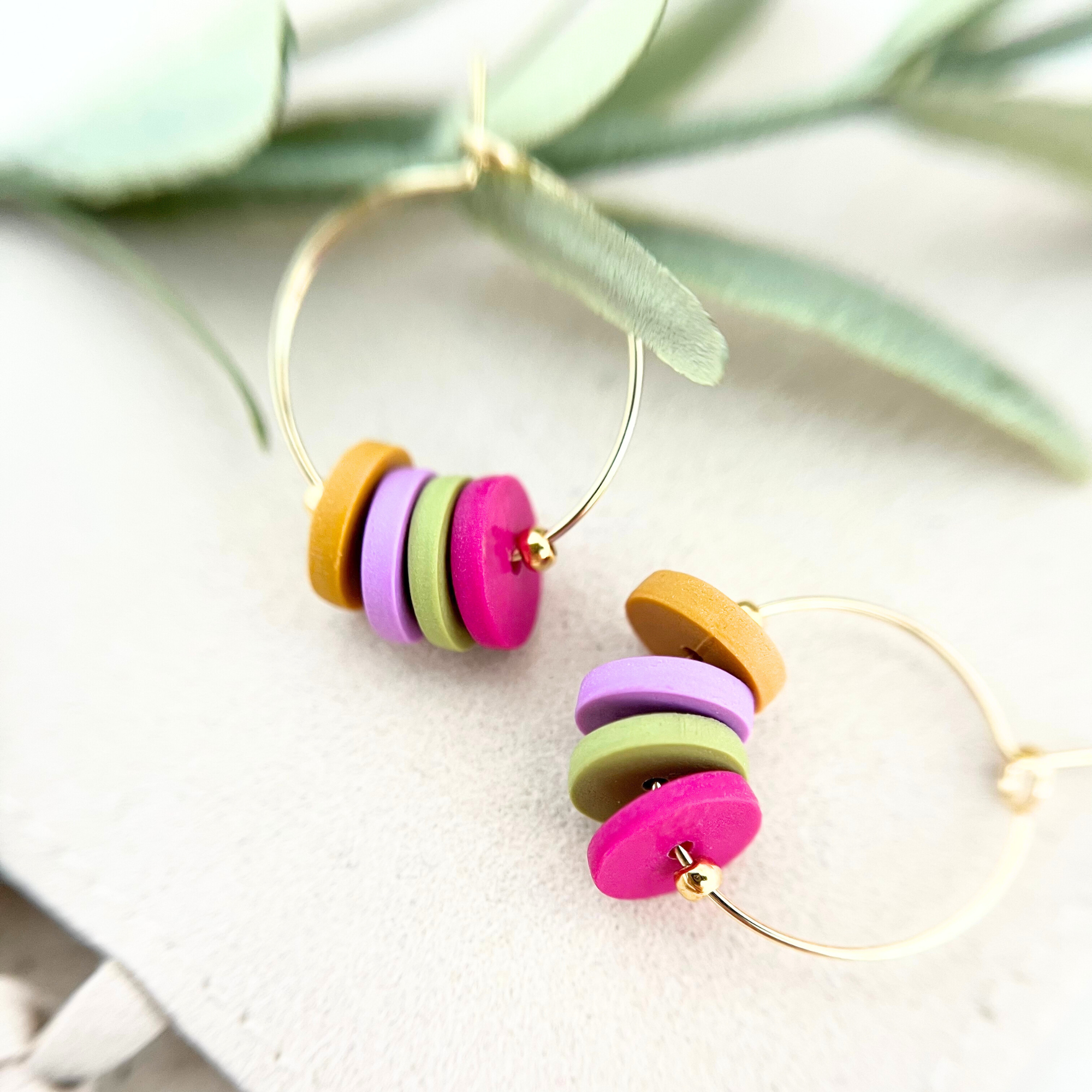 Handgemachte goldfarbene Creolen HOOPS aus Edelstahl mit bunten Polymer Clay-Anhängern, die einen verspielten, modernen Look verleihen
