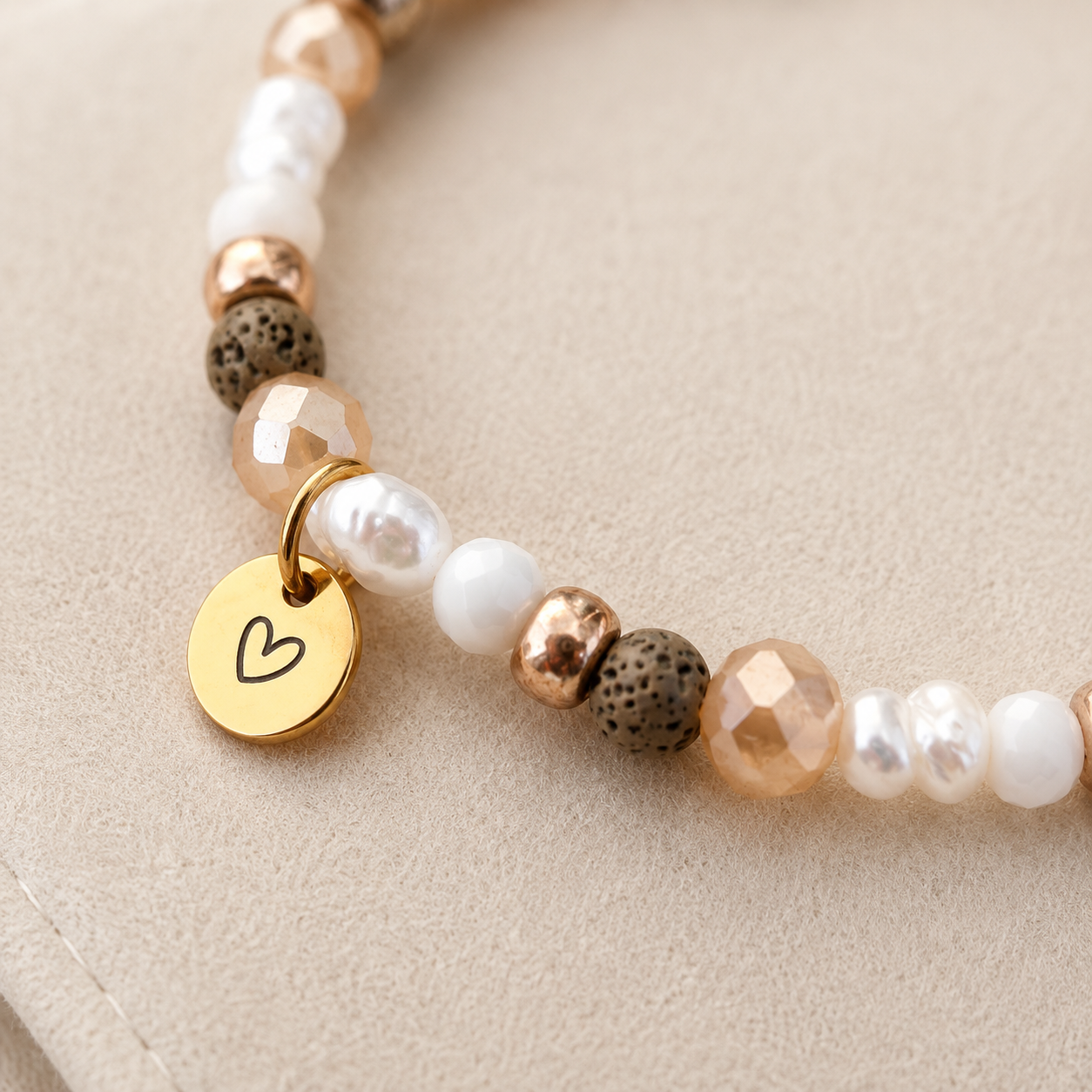 Detailaufnahme Naturstein Armband in Beige und Braun mit echten Süßwasserperlen, goldfarbenen Perlen und rundem Herz Gravuranhänger in Gold