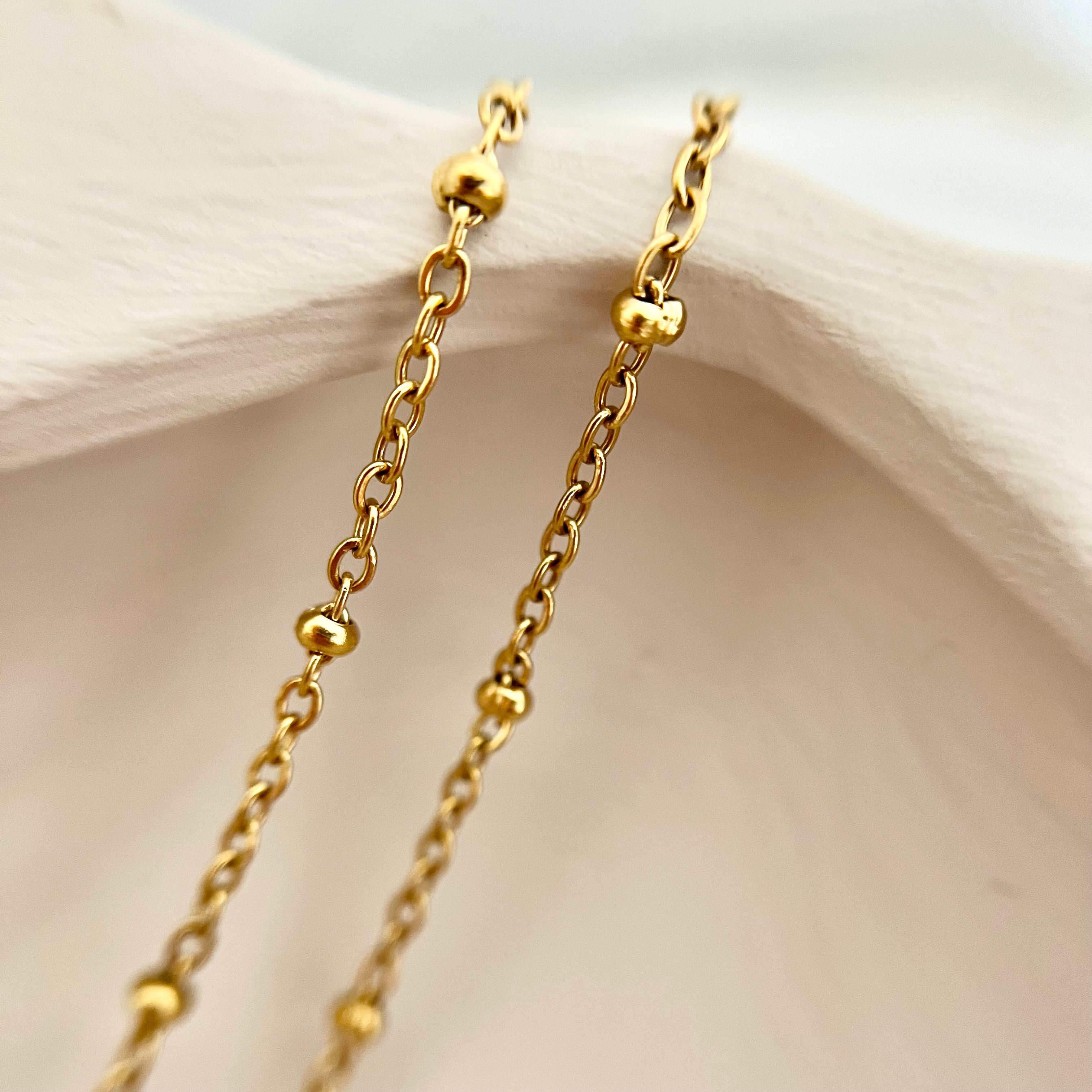 Detailaufnahme der filigranen goldenen Edelstahlkette der Kette PALMERA, die für einen eleganten, dezenten Look sorgt.