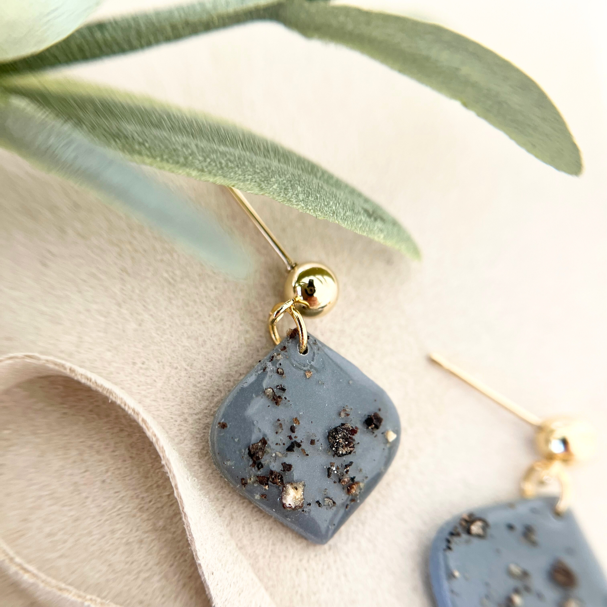 Detaillierte Nahaufnahme der Ohrringe PIMIENTA, die das individuelle Design mit echten Pfefferkörnern und glänzenden Edelstahl-Elementen zeigen