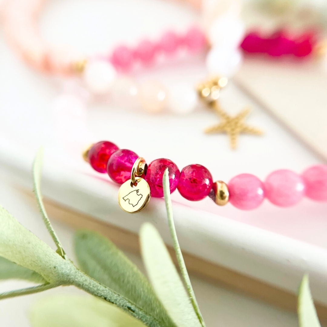 „DIY Armband mit transparenten pinken Glasperlen und personalisiertem Gravuranhänger mit Mallorca-Umriss – individuelles Schmuckstück aus dem Perlenschmuck Workshop in Wuppertal, ideal als JGA Idee oder Geschenk mit Bedeutung