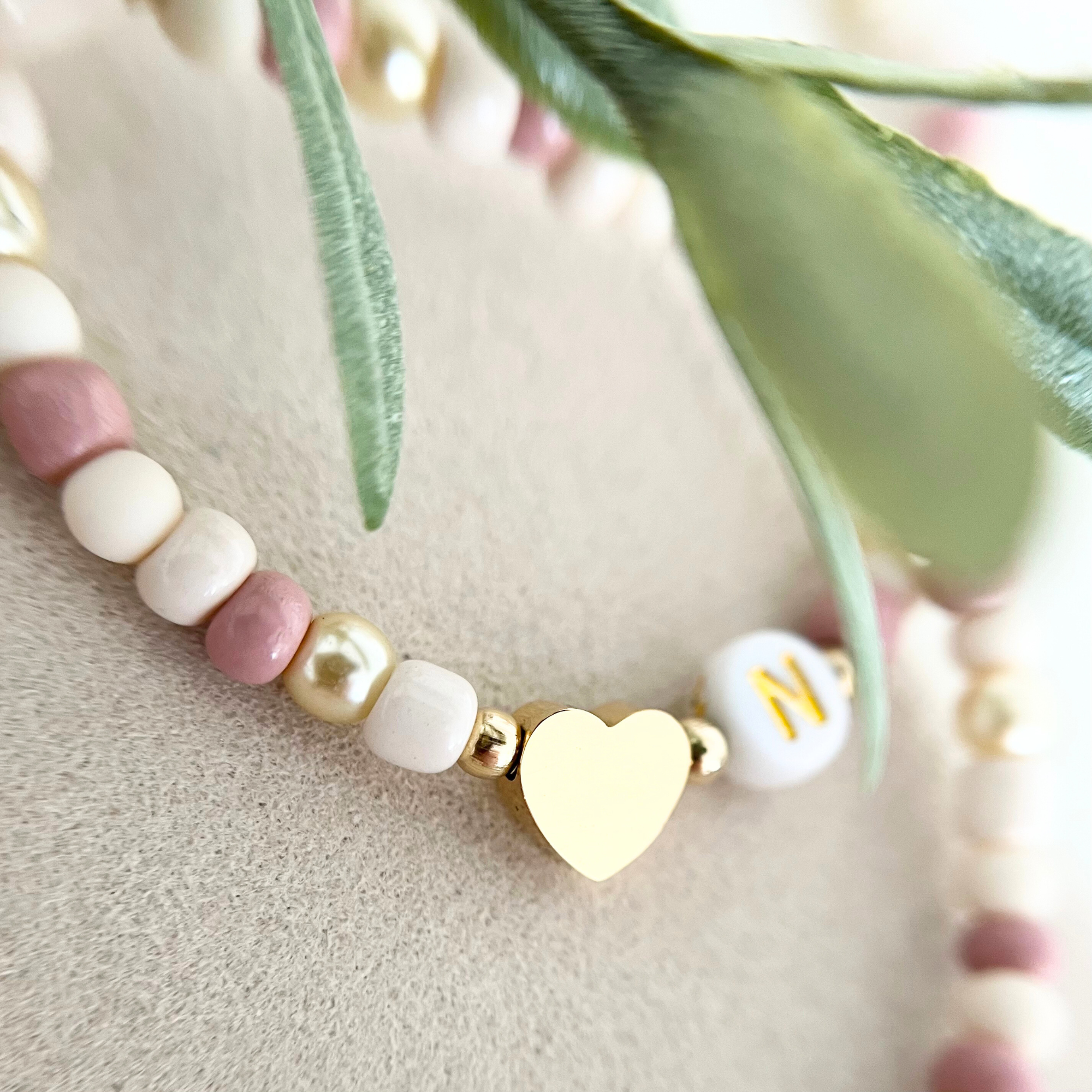 Goldfarbener Herzanhänger im Fokus – eleganter Anhänger für das DIY Armband Set ROSA, das deinem Armband eine persönliche Note verleiht.