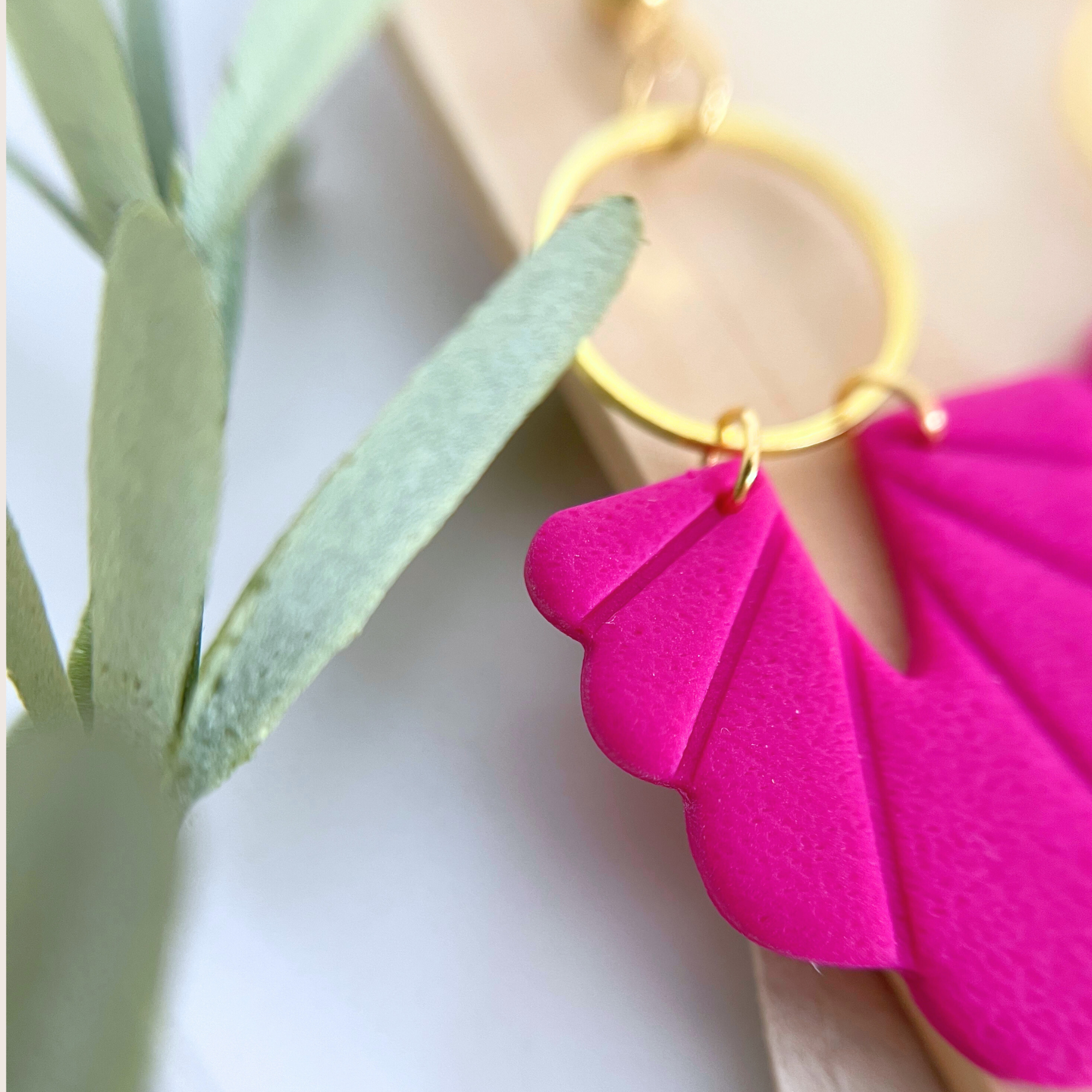 Nahaufnahme der Ohrringe PALMANOVA, pinke Muschelform aus Polymer Clay mit Edelstahl-Stecker, goldfarbene Variante