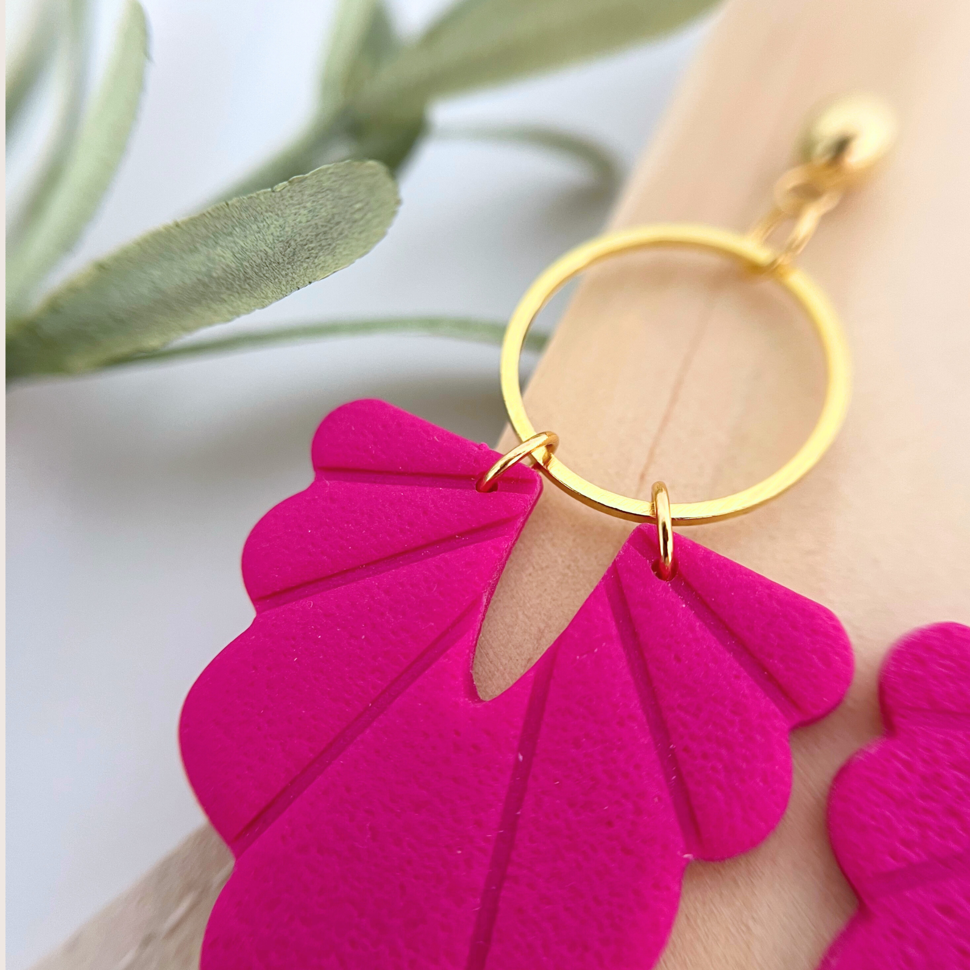 Detailaufnahme der Ohrringe PALMANOVA, Muschelform in intensivem Pink, auf Holz, goldfarbener Edelstahl-Stecker