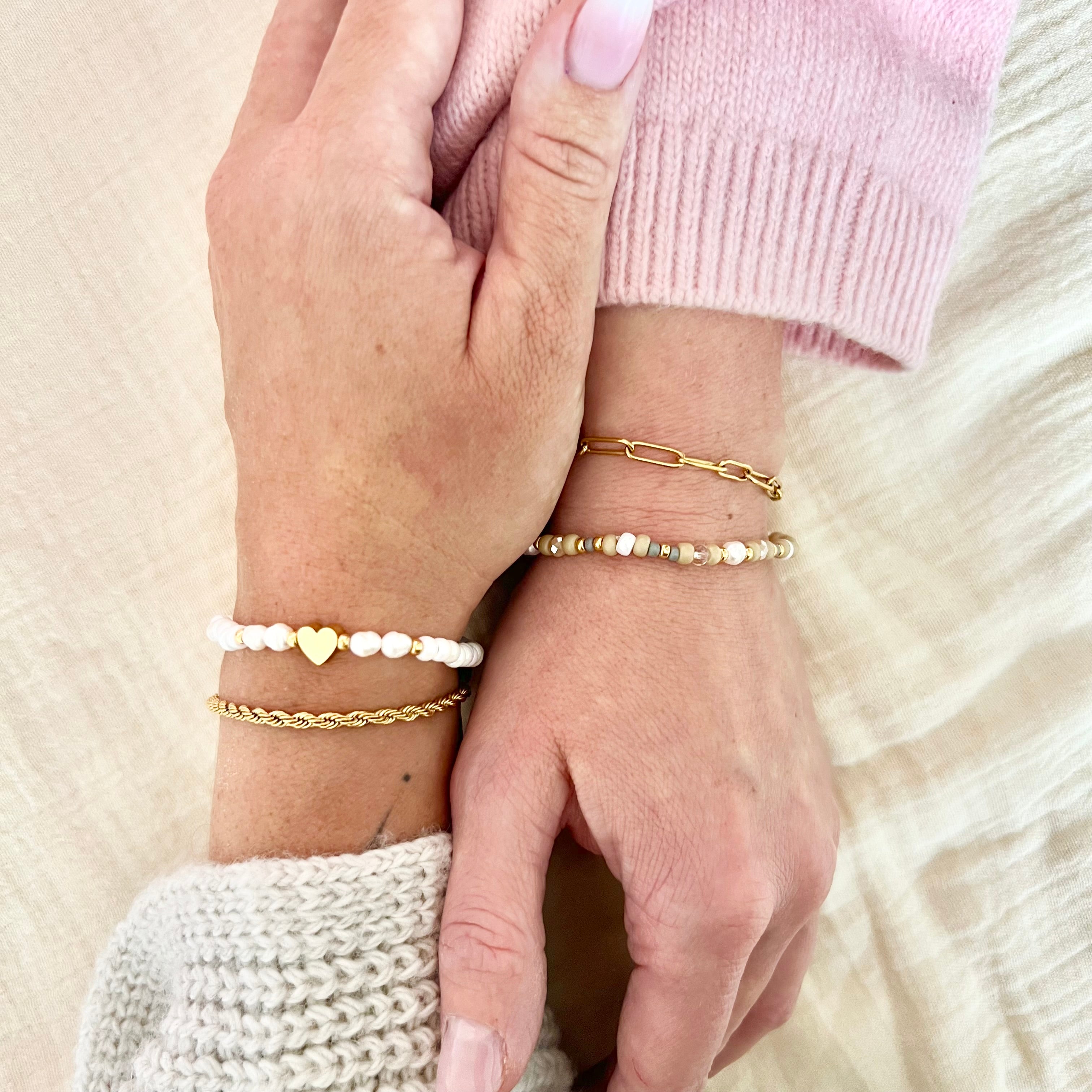 Zwei Freundinnen tragen das SOUL Armband-Set – ihre Hände berühren sich, die Armbänder glänzen in Gold und Weiß – Ausdruck tiefer Verbundenheit.