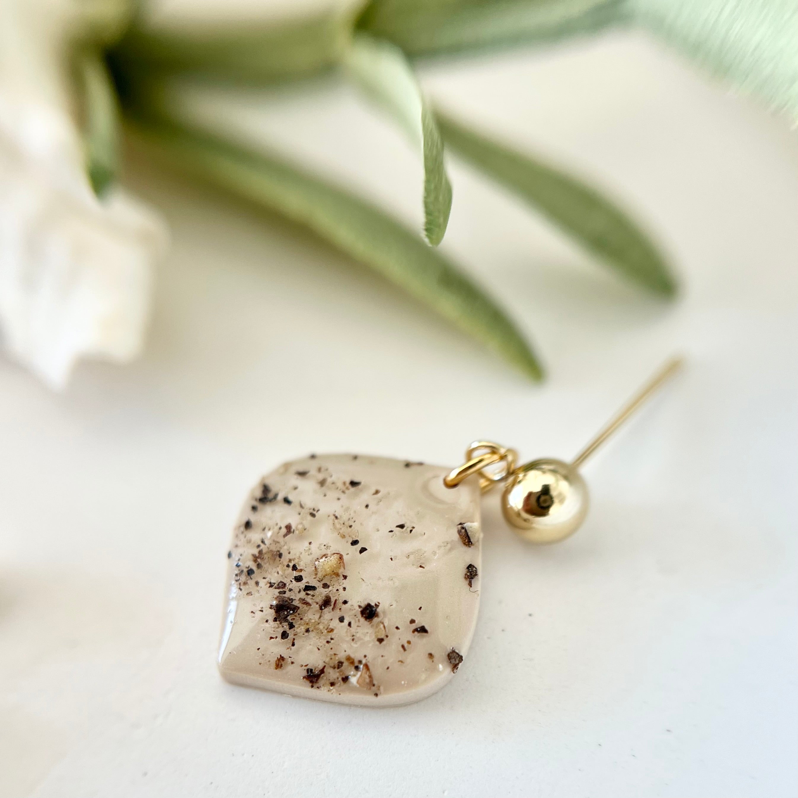 Nahaufnahme der handgemachten Ohrringe PIMIENTA mit einzigartigem Design, das Edelstahl, Polymer Clay und echte mallorquinische Pfefferkörner kombiniert