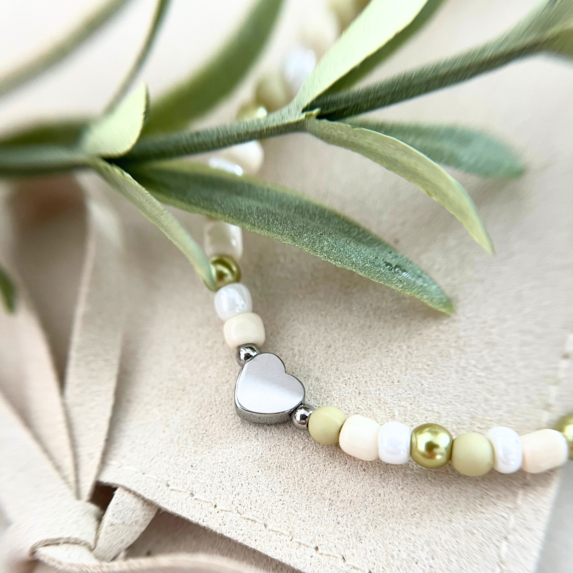 Nahaufnahme des Armbands mit silbernem Herzanhänger aus dem DIY Kit VERDE. Ideal für Freundschaftsarmbänder und individuelle Schmuckkreationen.