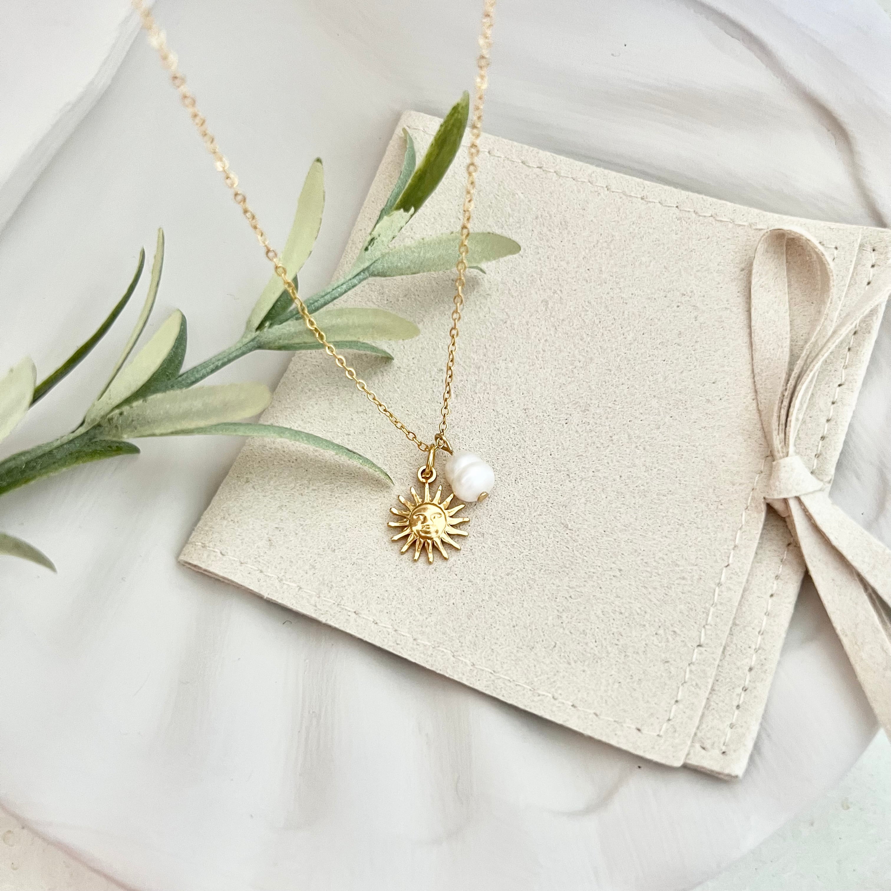 Gesamtansicht der Kette ALICANTE, drapiert auf einer Tasche, mit grünem Gestrüpp im Hintergrund, das die natürliche Eleganz des Designs unterstützt.