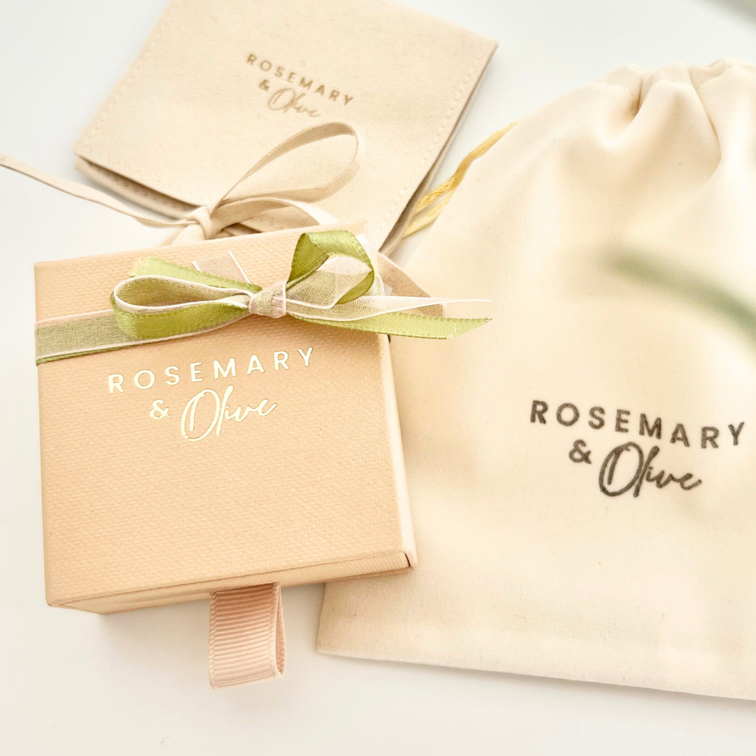Verpackungsset von Rosemary & Olive mit Geschenkbox, Samttäschchen und Stoffbeutel – hochwertige Schmuckverpackung in Beige mit grüner Schleife.
