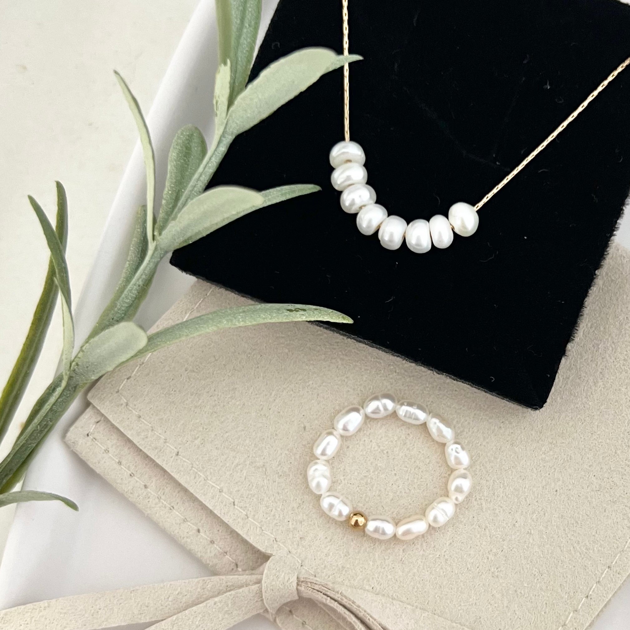 Perlenring PALMA von oben fotografiert, kombiniert mit einer Perlenkette – zeitlose Eleganz und harmonisches Design.