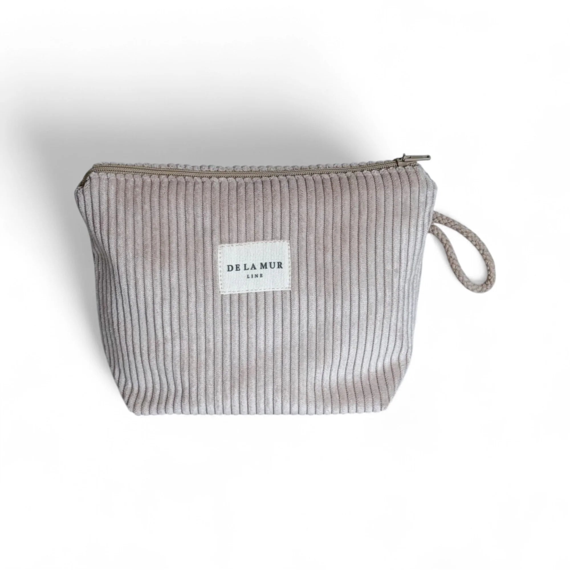 Sanftes Taupe, weicher Cord und handgefertigte Qualität – die DE LA MUR Beauty Bag ist ein zeitloses Essential für Pflegeprodukte, Make-up und kleine Reisebegleiter.