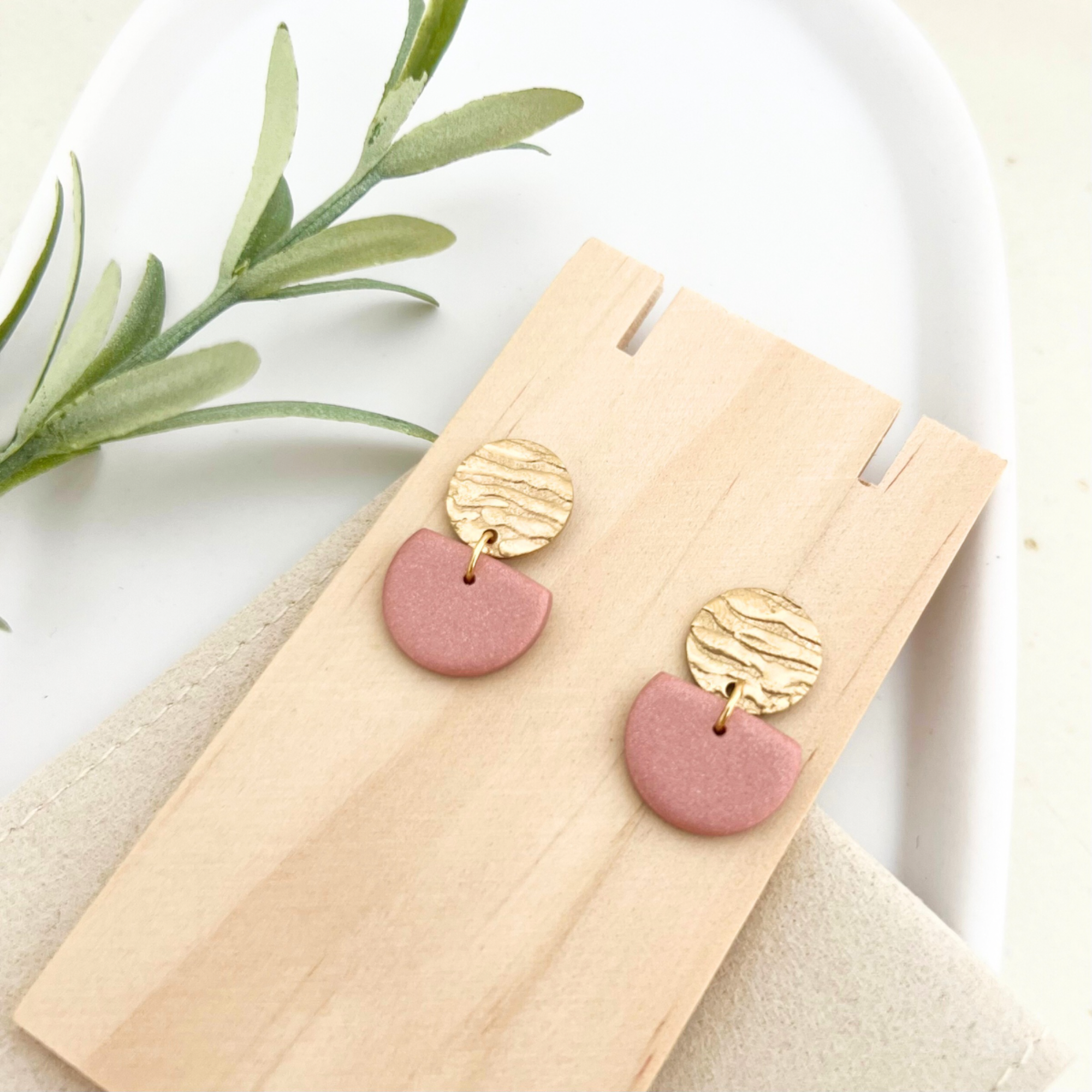 Paar goldene Edelstahl-Ohrringe SOL mit gehämmertem Stecker, die die eleganten Farben in Bronze, Beige und Taupe aus Polymer Clay perfekt zur Geltung bringen.