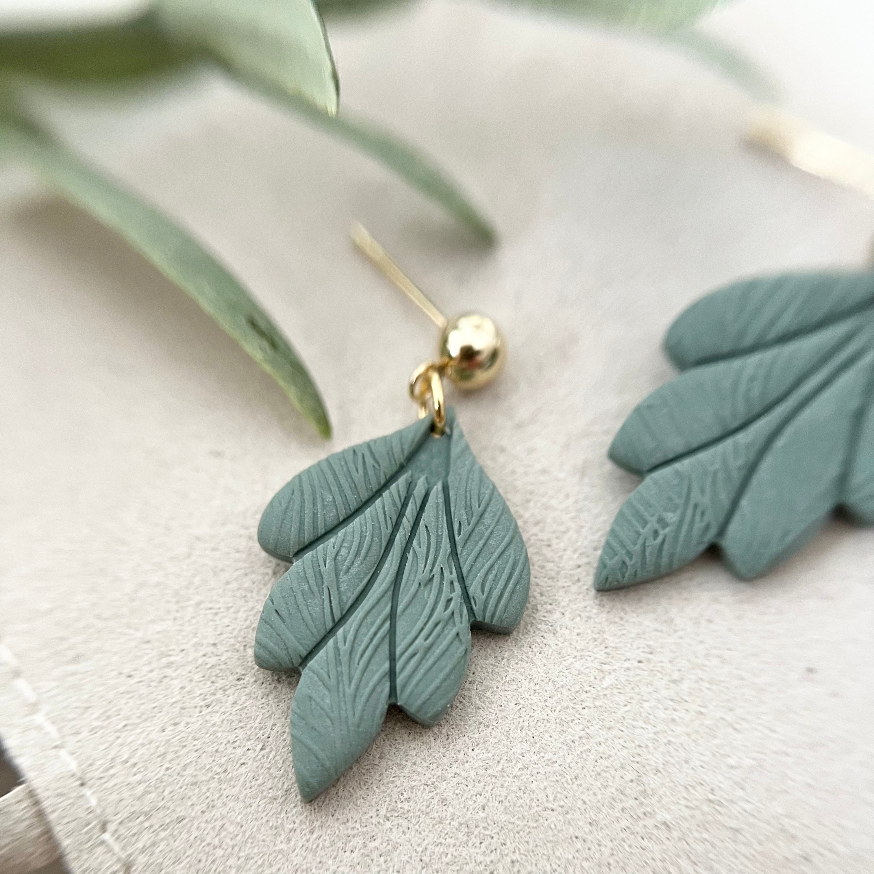 Nahaufnahme eines Ohrrings TAORMINA in Weiß, gefertigt aus Edelstahl und Polymer Clay, das die schlichte Eleganz des Designs zeigt