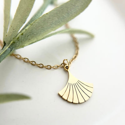Nahaufnahme der goldenen Edelstahlkette DEIA mit einem filigranen Ginkgo-Blatt Anhänger, der für Stärke und Langlebigkeit steht.