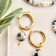 Detailaufnahme der Ohrringe FAYA mit Dalmatiner Jaspis Natursteinperle, individuelle schwarz-graue Marmorierung, hochwertiger Schmuck zum Tragen im Alltag.