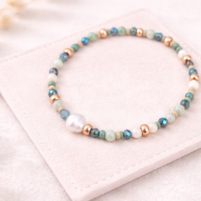 Perlenarmband in Blau-, Grün- und Weißtönen mit Süßwasserperle und goldenen Details auf hellem Wildlederpad – DIY Armband aus Perlenarmband Set