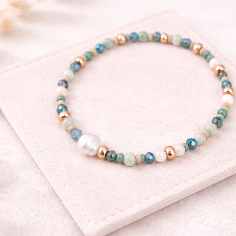 Perlenarmband in Blau-, Grün- und Weißtönen mit Süßwasserperle und goldenen Details auf hellem Wildlederpad – DIY Armband aus Perlenarmband Set