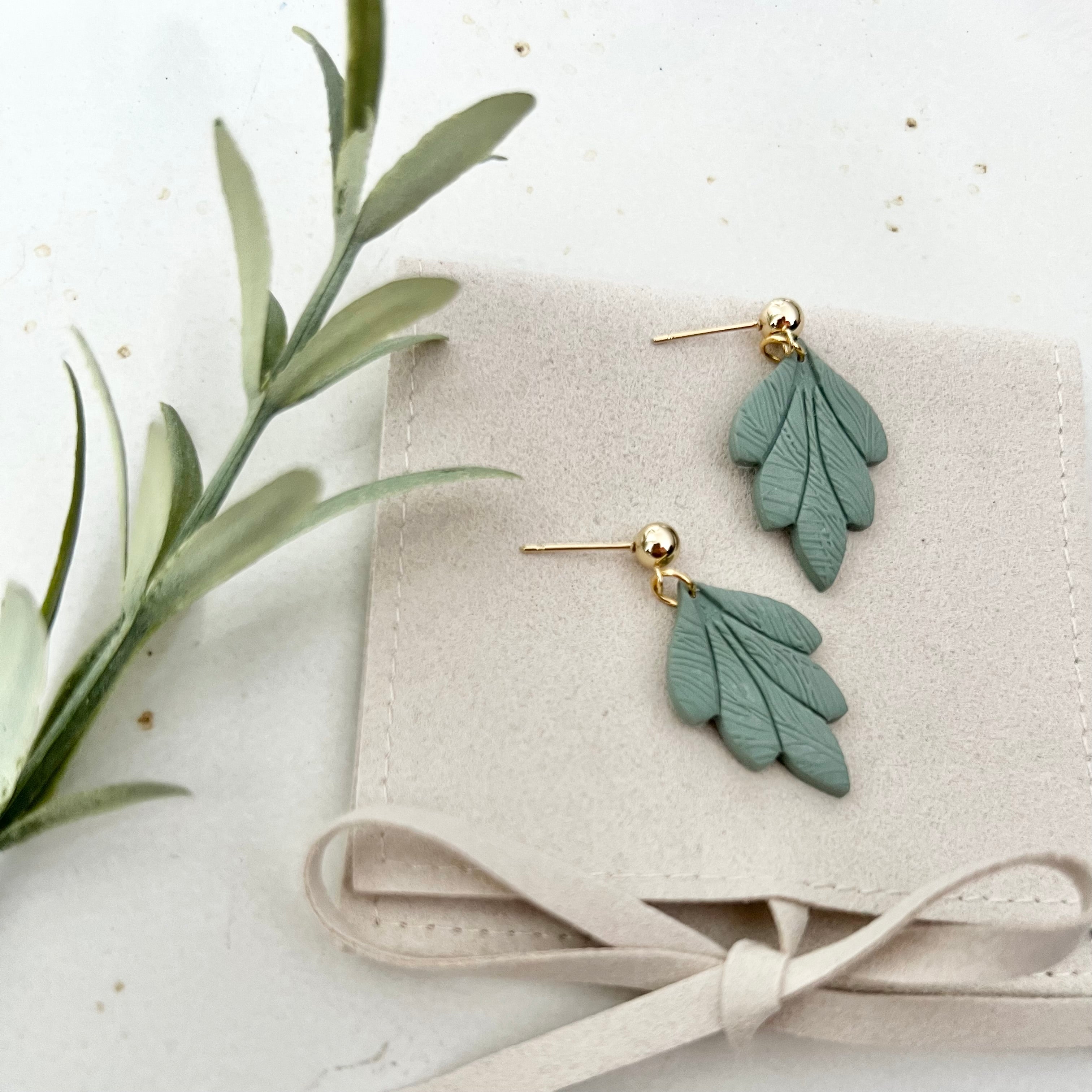 Elegantes Paar Ohrringe TAORMINA in sanften Farben auf einer Tasche, ideal für Hochzeiten oder den Alltag