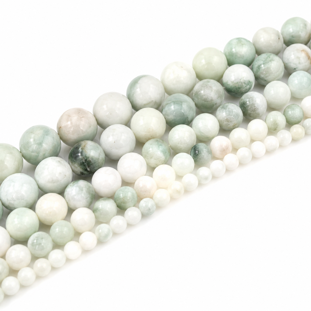 Detailaufnahme eines Jade Perlenstrangs mit runden Natursteinperlen in Weiß und sanften Grüntönen.