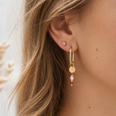 Goldene Creole mit Perlenanhänger in Rosa, Pink und Weiß am Ohr getragen, gehämmerter Anhänger und filigrane Perlen, Schmuck für Frauen in natürlichem Licht