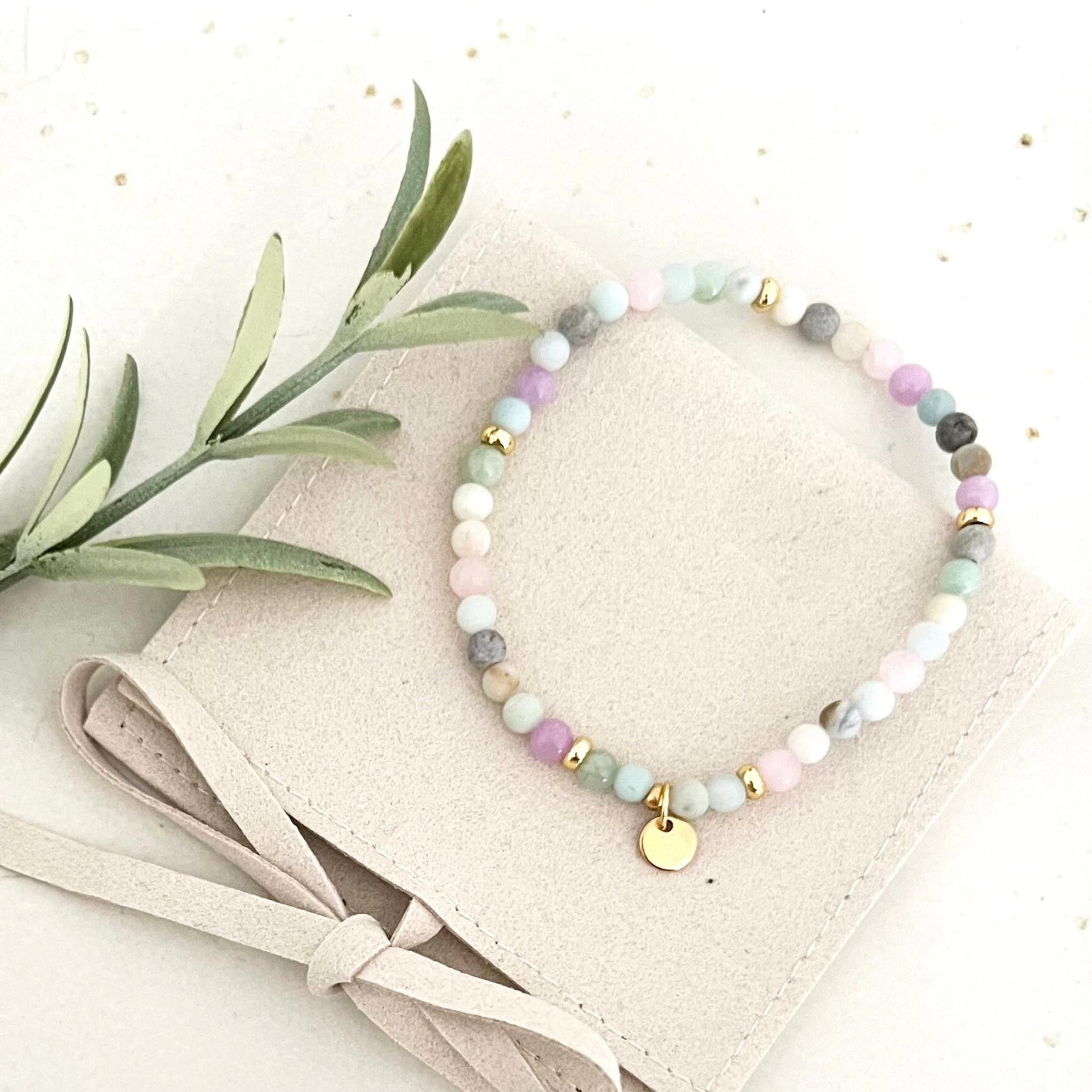 Vogelperspektive des Armbands PORTOFINO, das die Kombination von Natursteinperlen und Rosenquarz zeigt, in einer eleganten Tasche