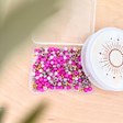 DIY Perlenarmband Set mit pinken und grauen Perlen sowie goldenen Zwischenperlen in transparenter Aufbewahrungsbox