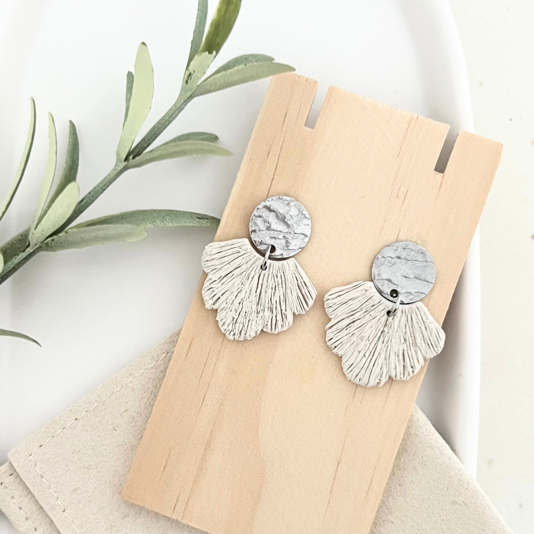 Ohrringe PALERMO im Boho-Stil mit silberfarbenem Steckverschluss und fächerförmigem Polymer Clay-Anhänger, abgebildet auf Holz.