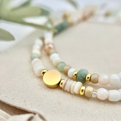 Nahaufnahme von zwei Armbändern – Fokus auf goldene Perlen und Aventurin Perle, die für Ausgeglichenheit und Harmonie stehen
