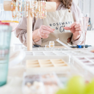 Eine Person sitzt am Tisch beim Workshop und fertigt etwas an – kreative Auszeit beim exklusiven Schmuck Workshop
