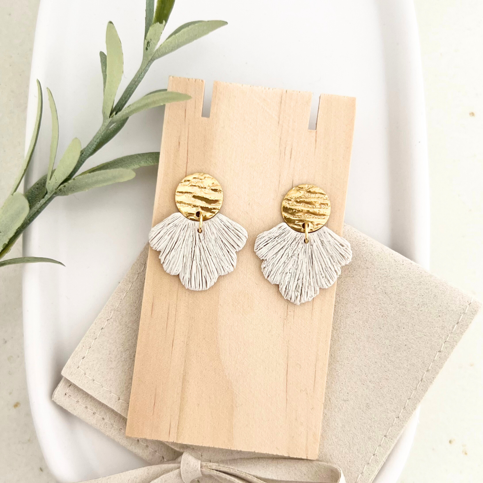 Handgemachte Ohrringe PALERMO mit fächerförmigem Polymer Clay-Anhänger und goldfarbenem Edelstahl-Steckverschluss auf Holz arrangiert.