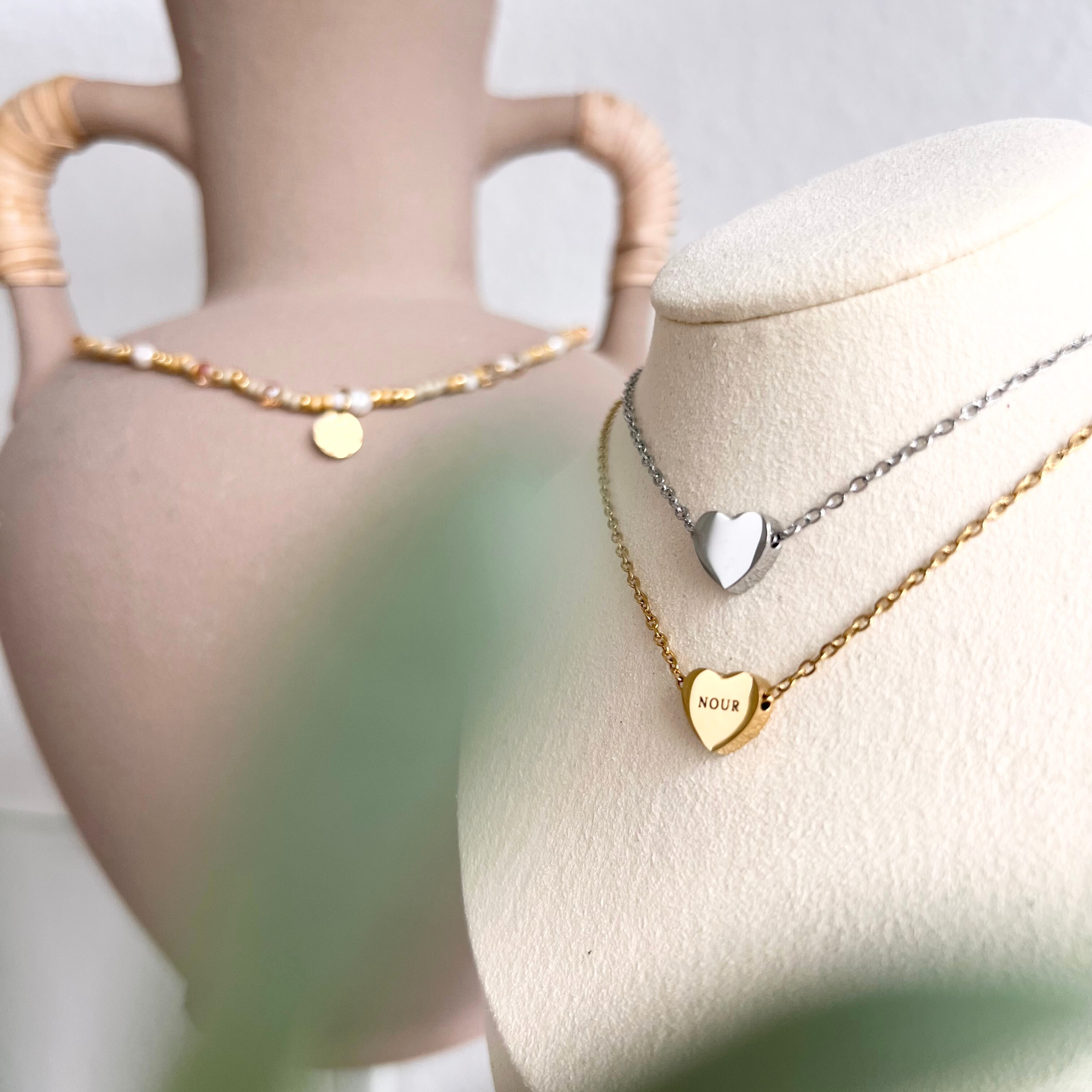 Personalisierte Herzkette mit Herzanhänger aus Edelstahl in Gold und Silber auf Schmuckbüste, minimalistische Halskette mit Namensgravur