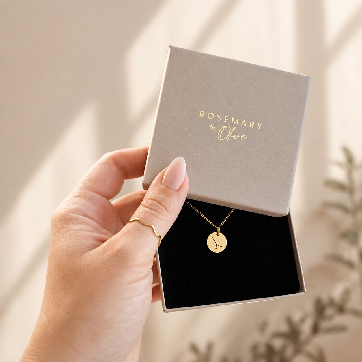 Goldene Sternzeichen-Kette mit rundem Gravur-Anhänger und Sternbild in einer Schmuckbox von Rosemary & Olive aus Wuppertal – personalisierte Kette als Geschenk zum Geburtstag oder Weihnachten.