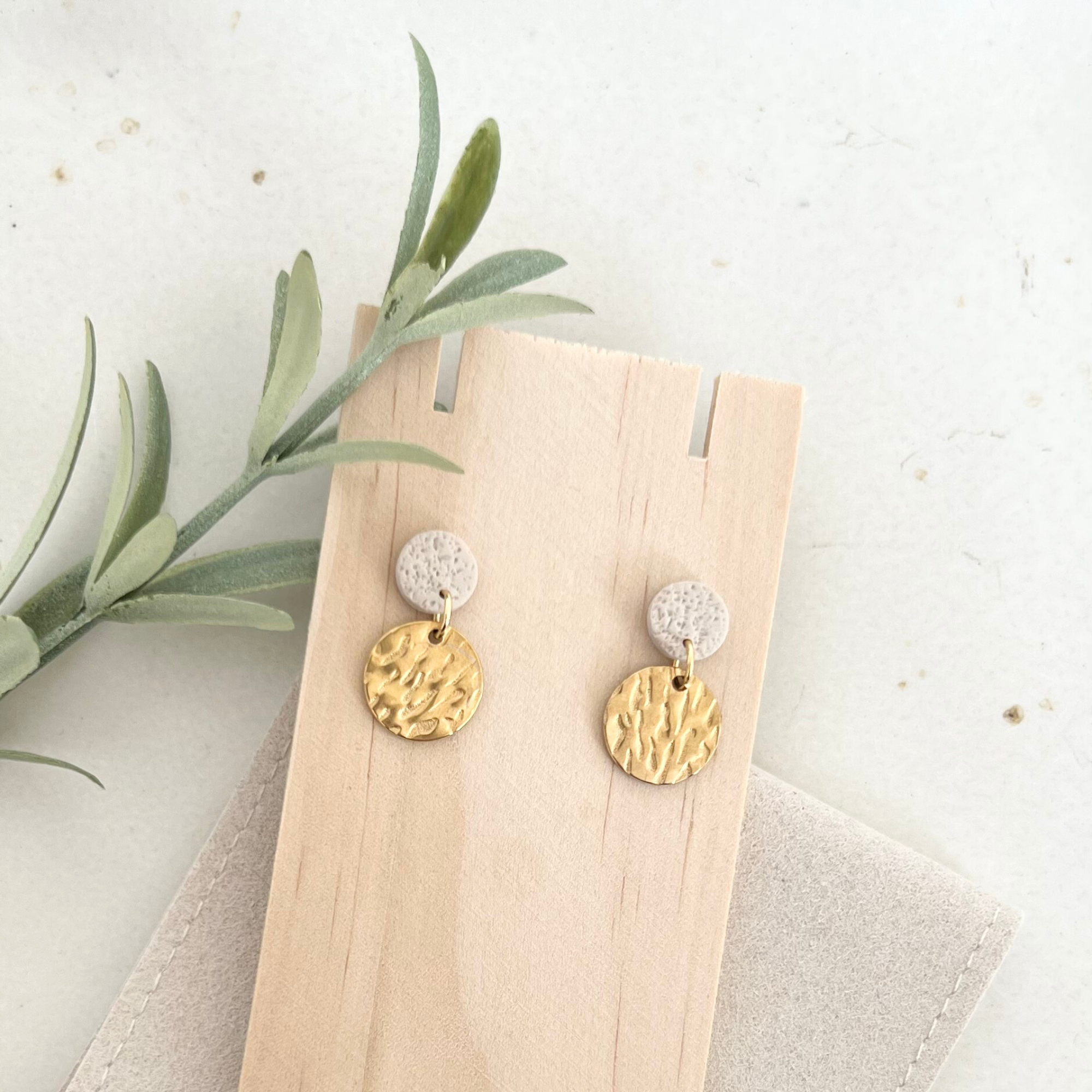 Paar Ohrstecker ALARO auf Holz arrangiert, mit goldfarbenem Edelstahl und natürlicher Beige- und Apricot-Farbgebung