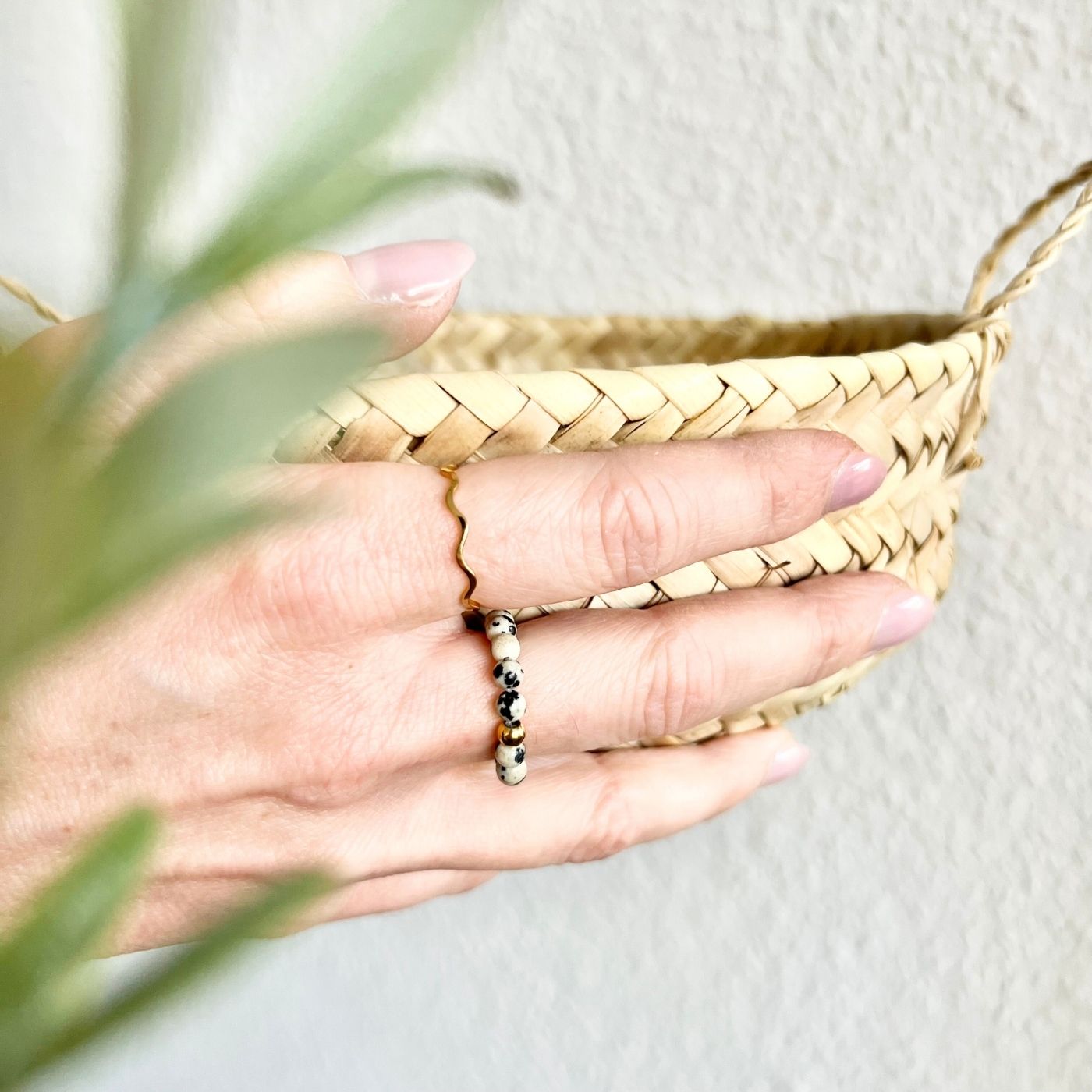 Perlenring aus Dalmatiner Jaspis am Finger getragen, auf Elastikband gearbeitet, wasserfester Schmuck für den Alltag mit natürlicher schwarz-grauer Marmorierung.