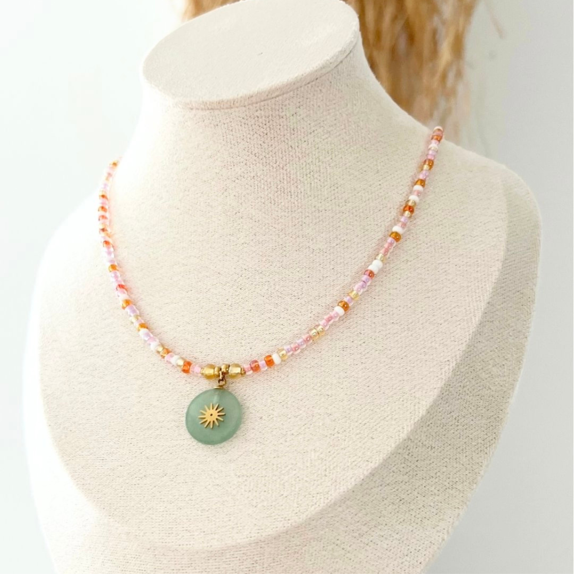 Kette ARTÀ mit einem Naturstein-Sonnenanhänger auf einer Halsattrappe, die den fröhlichen, sommerlichen Charme des Schmuckstücks zeigt.