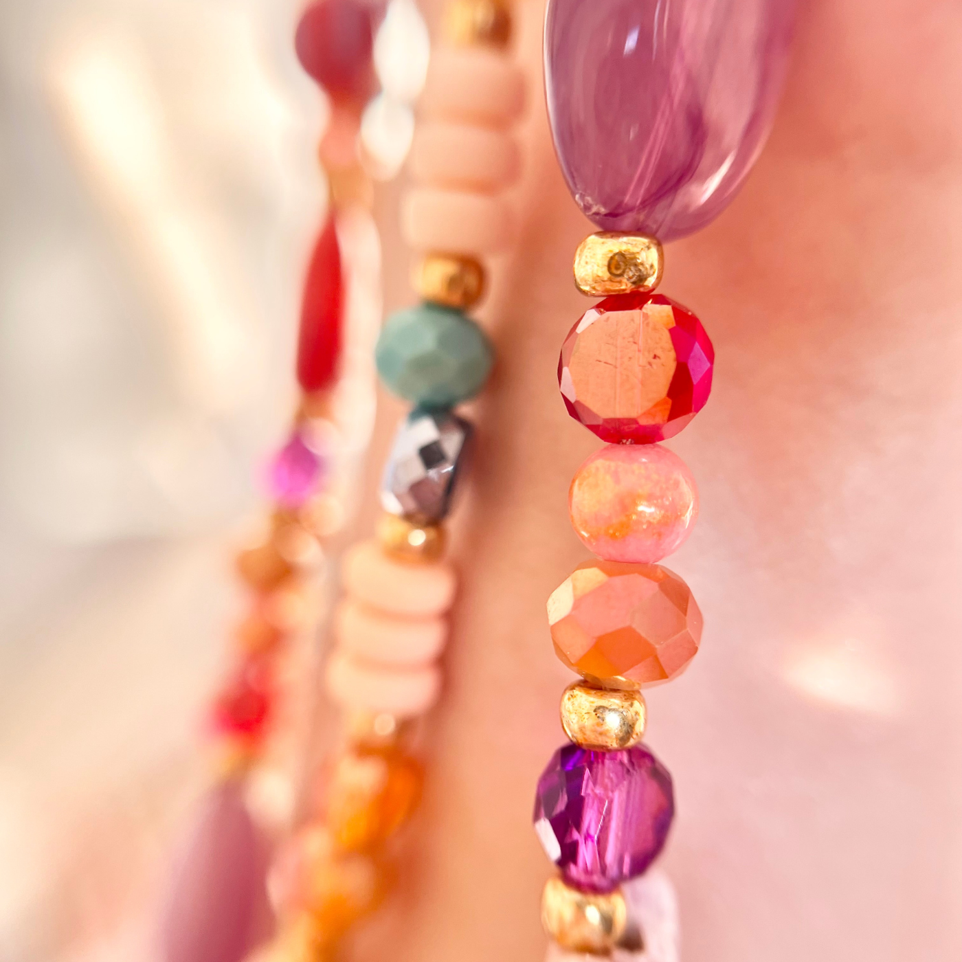 Detailaufnahme einer bunten Perlen-Handykette mit Natursteinperlen, facettierten Glasperlen und goldenen Miyuki-Perlen – handgemachte Handykette als sommerliches Phone Strap Accessoire.